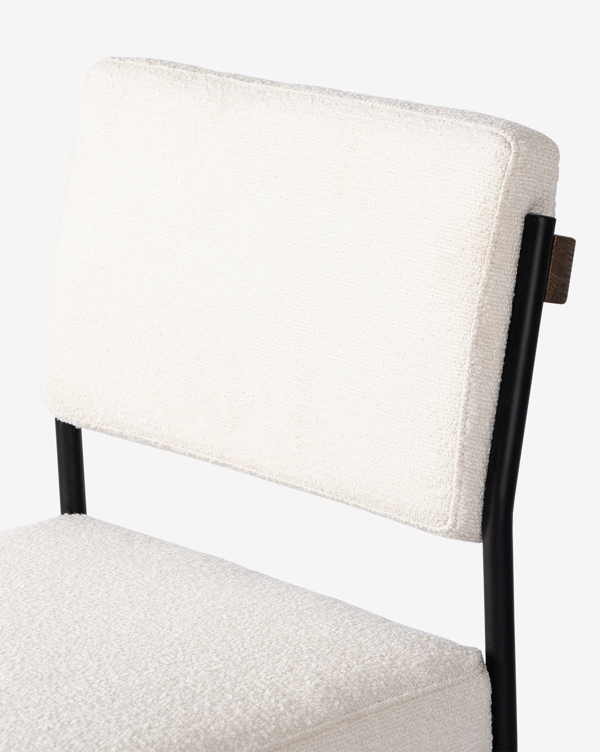 Close-up of the Pascal Dining Chair, showcasing its textured white upholstered backrest and seat with a steel and wood frame, set against a plain white background—ideal for any dining table, by McGee & Co.