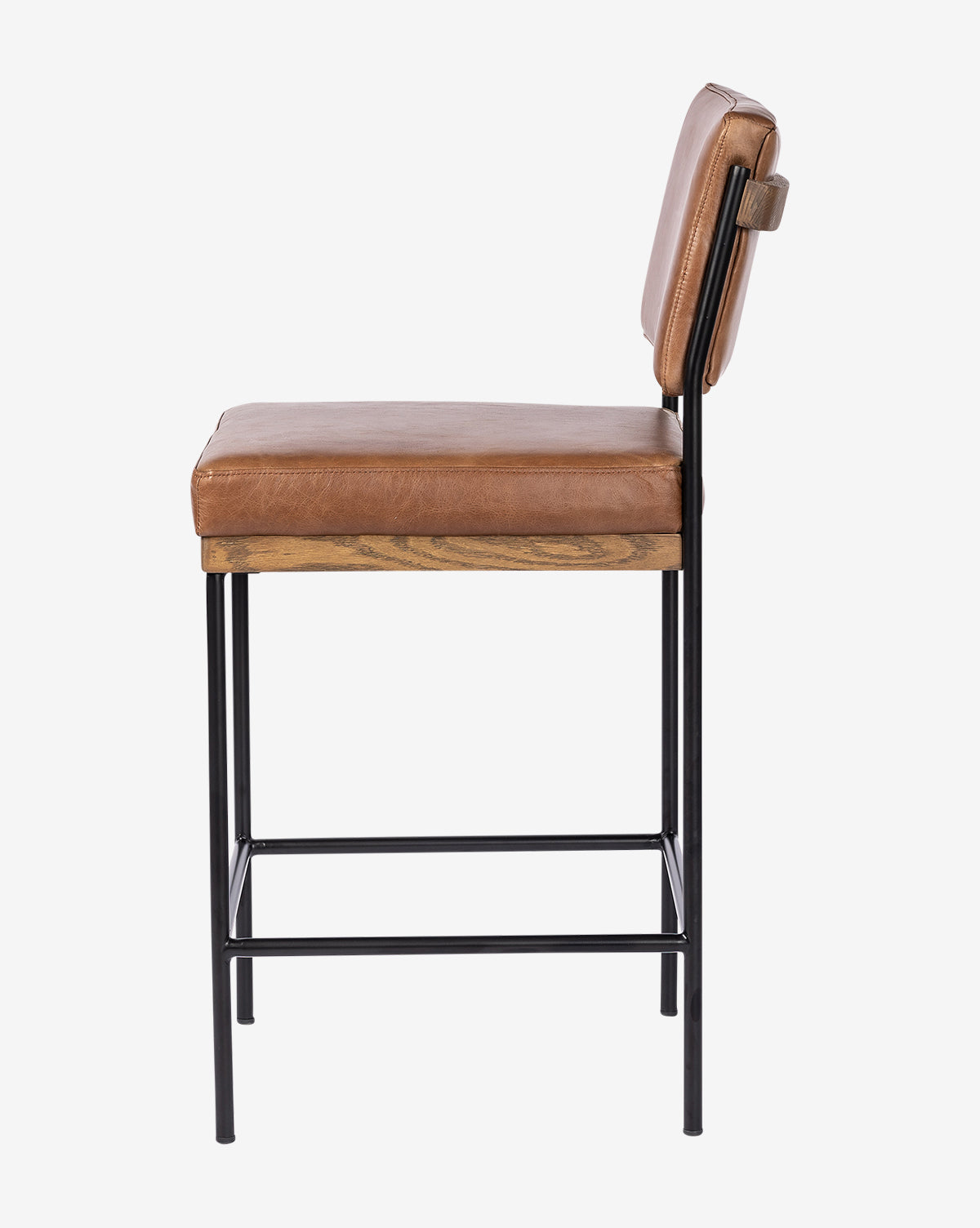 The Pascal Stool is a versatile chair with a tan leather seat and backrest, wooden seat base, black iron frame legs, and a handy footrest—shown here from the side view by McGee & Co.