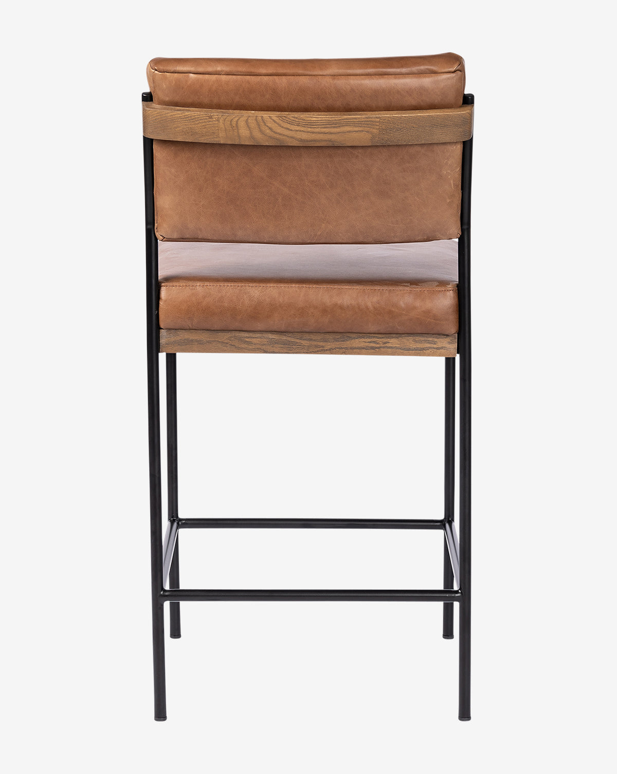 The Pascal Stool features a tan leather seat and backrest, wooden accents, and a black iron frame with four straight legs and a footrest, by McGee & Co.