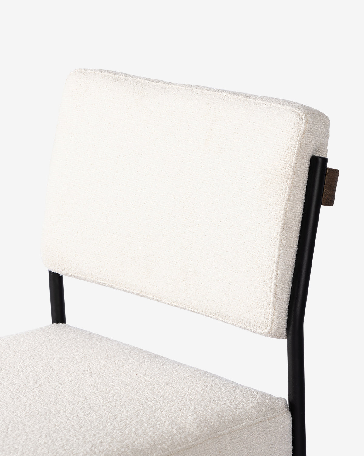A close-up of the Pascal Stool shows its white textured cushion and backrest on a slim black iron frame, set against a plain white background, by McGee & Co.
