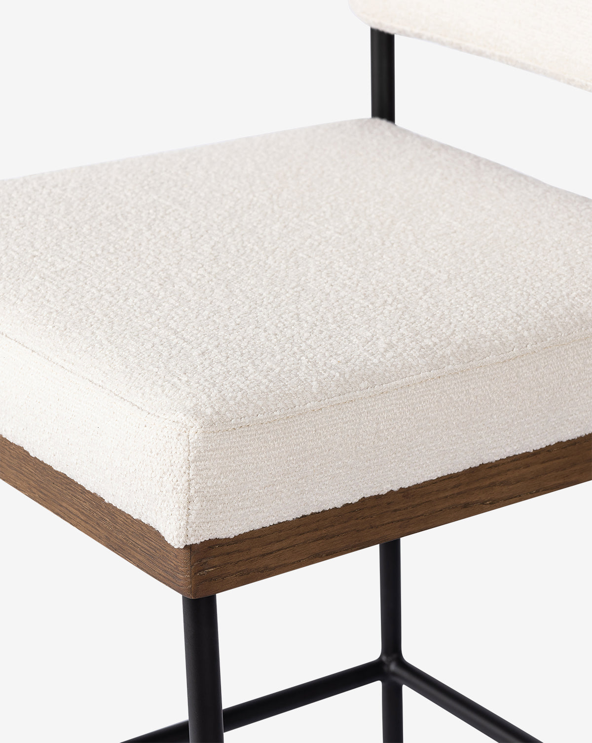 Close-up of the Pascal Stool, showcasing its textured off-white upholstered seat, dark wood base, and slender black iron legs, by McGee & Co.