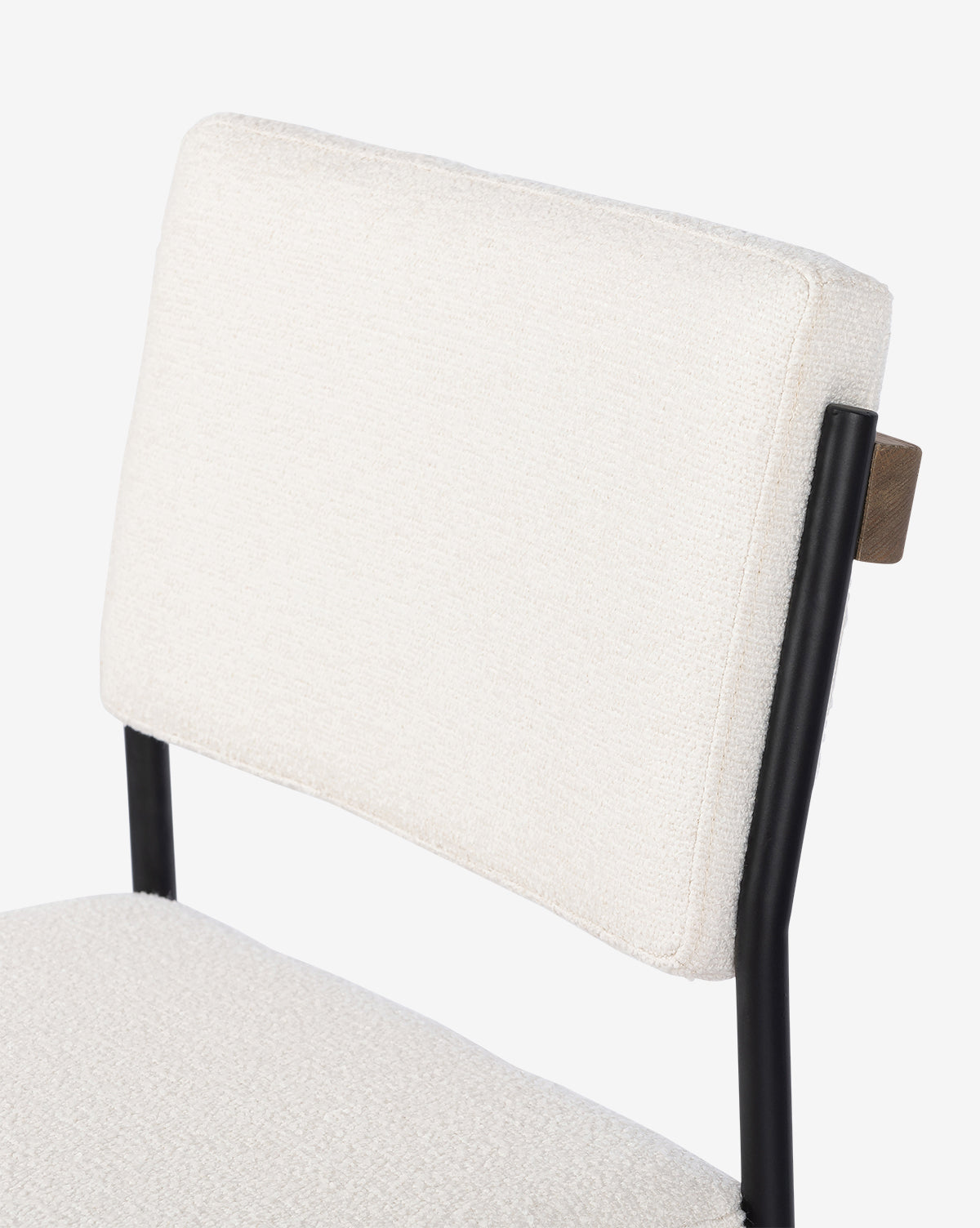 Close-up of the backrest and seat of the Pascal Stool, featuring textured off-white fabric and a black iron frame, set against a plain white background, by McGee & Co.