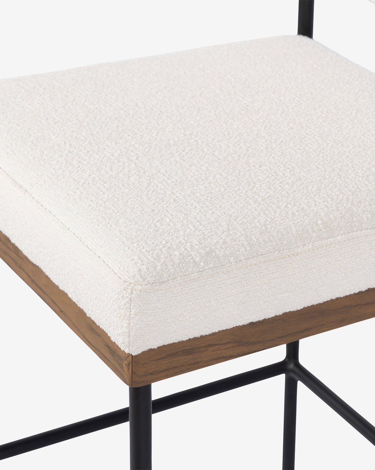 Close-up of the Pascal Stool, showcasing its off-white textured upholstered seat cushion, wooden trim, and black iron frame. The image highlights the stool’s quality materials and construction, by McGee & Co.