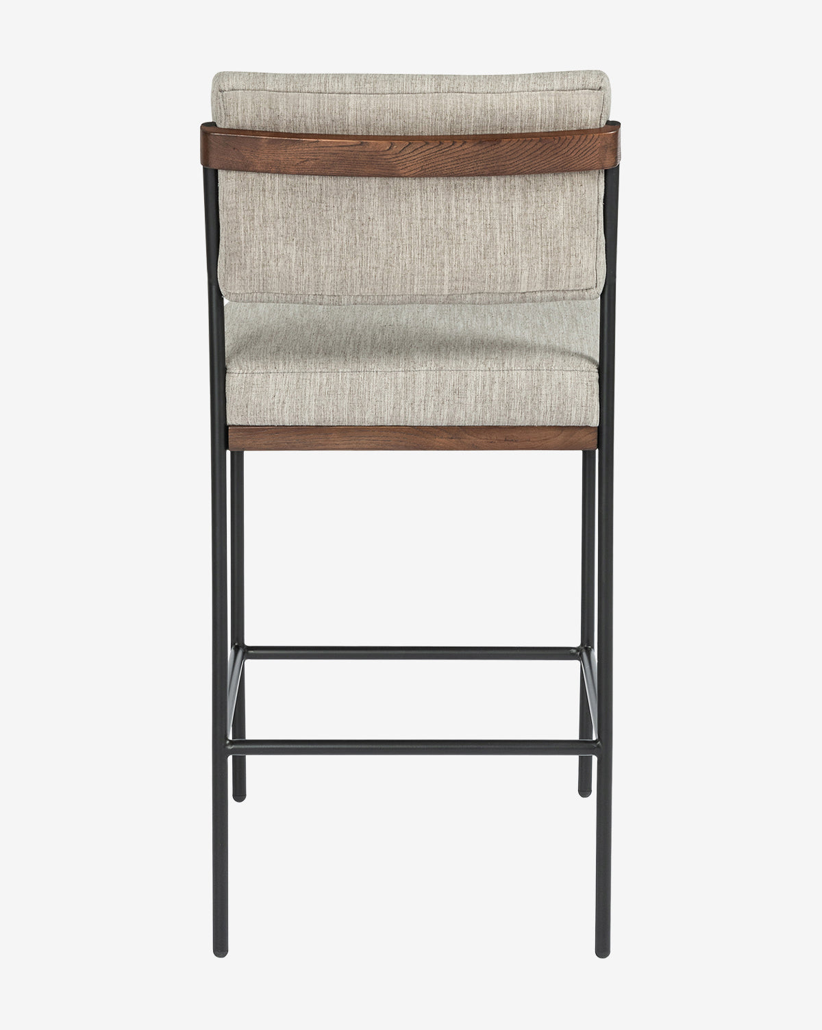 A back view of the Pascal Stool highlights its light gray padded fabric seat and backrest, dark wood accents, and a black iron frame with footrests, by McGee & Co.