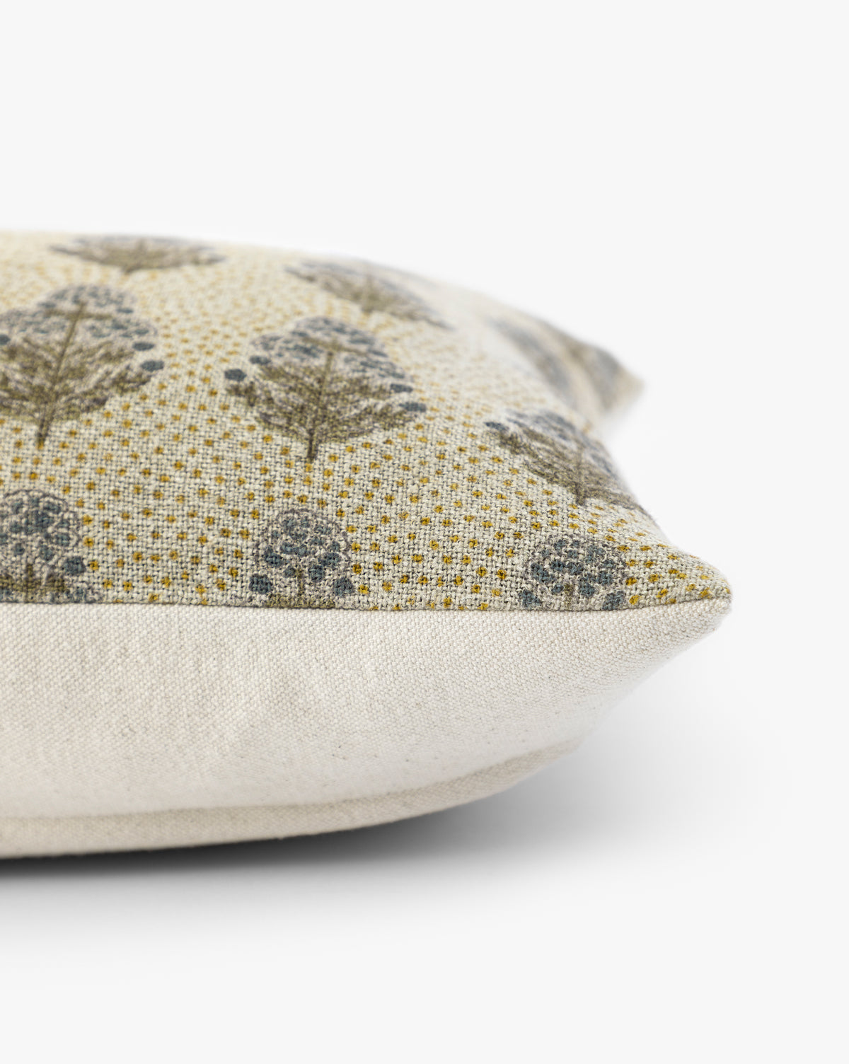 A close-up side view of the Patricia Pillow Cover, featuring textured beige fabric and a gray leafy tree pattern on a yellow background with earthy tones, displayed on a white surface, by McGee & Co.