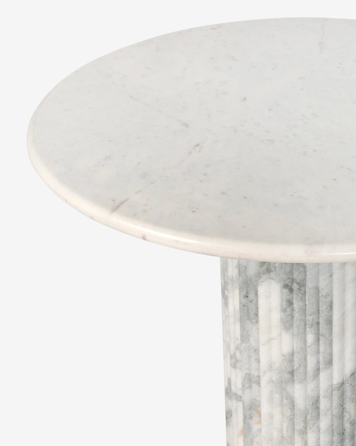 A close-up of the Patrick Dining Table, featuring a round white marble top with subtle grey veining and a fluted cylindrical pedestal base, exemplifying contemporary style against a plain light grey background by McGee & Co.