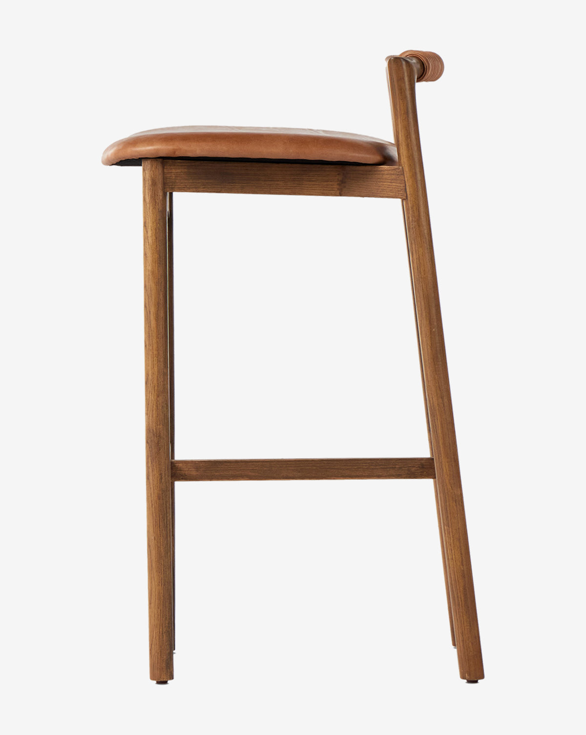 The Patrin Stool by Four Hands showcases an ash wood frame and a brown performance leather-upholstered seat with a low backrest, displayed in profile against a plain white background. McGee & Co.