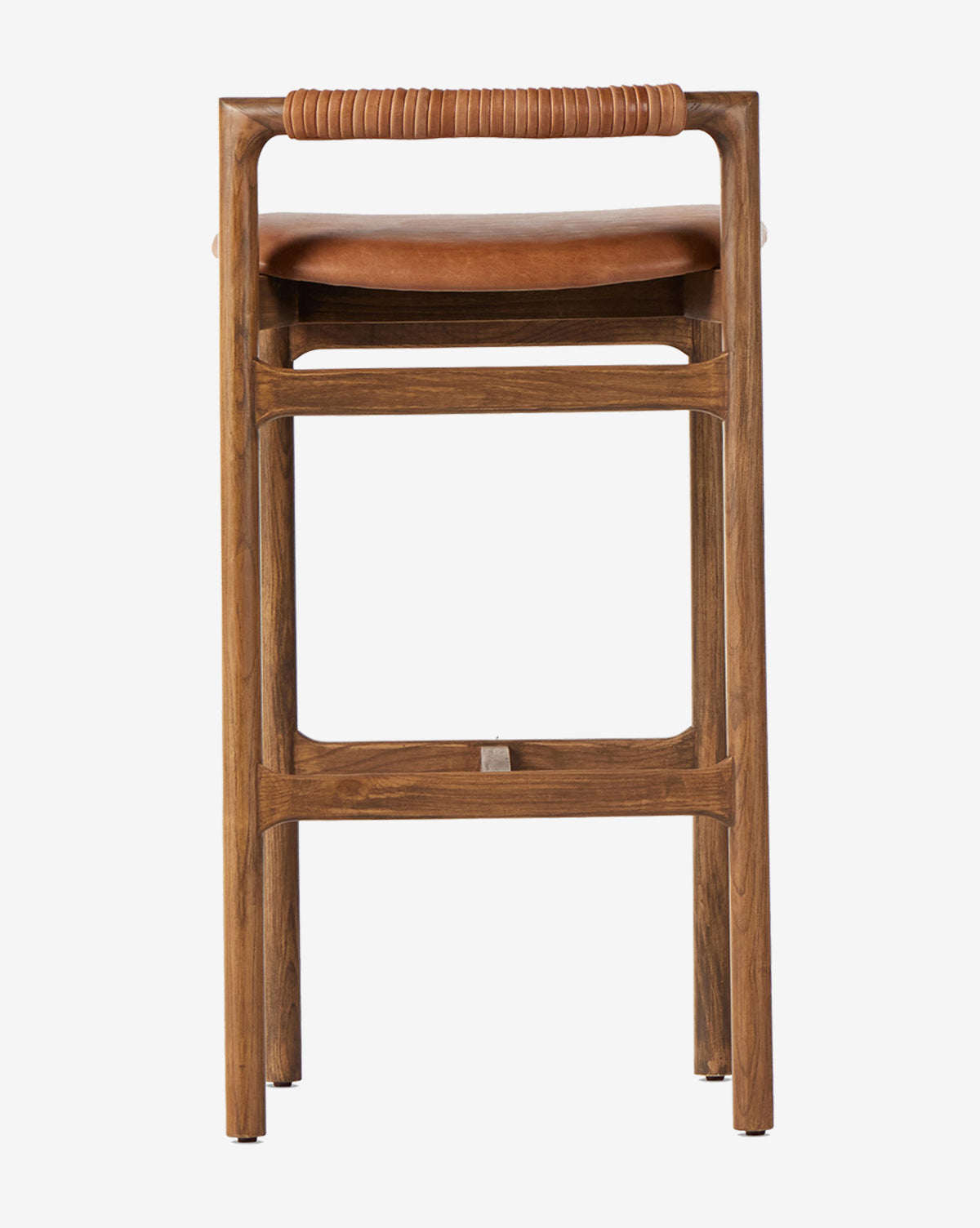 The Patrin Stool by Four Hands boasts a sturdy ash wood frame, leather-wrapped backrest, brown performance-upholstered seat, and a simple modern design with straight legs and a rectangular seat. McGee & Co.