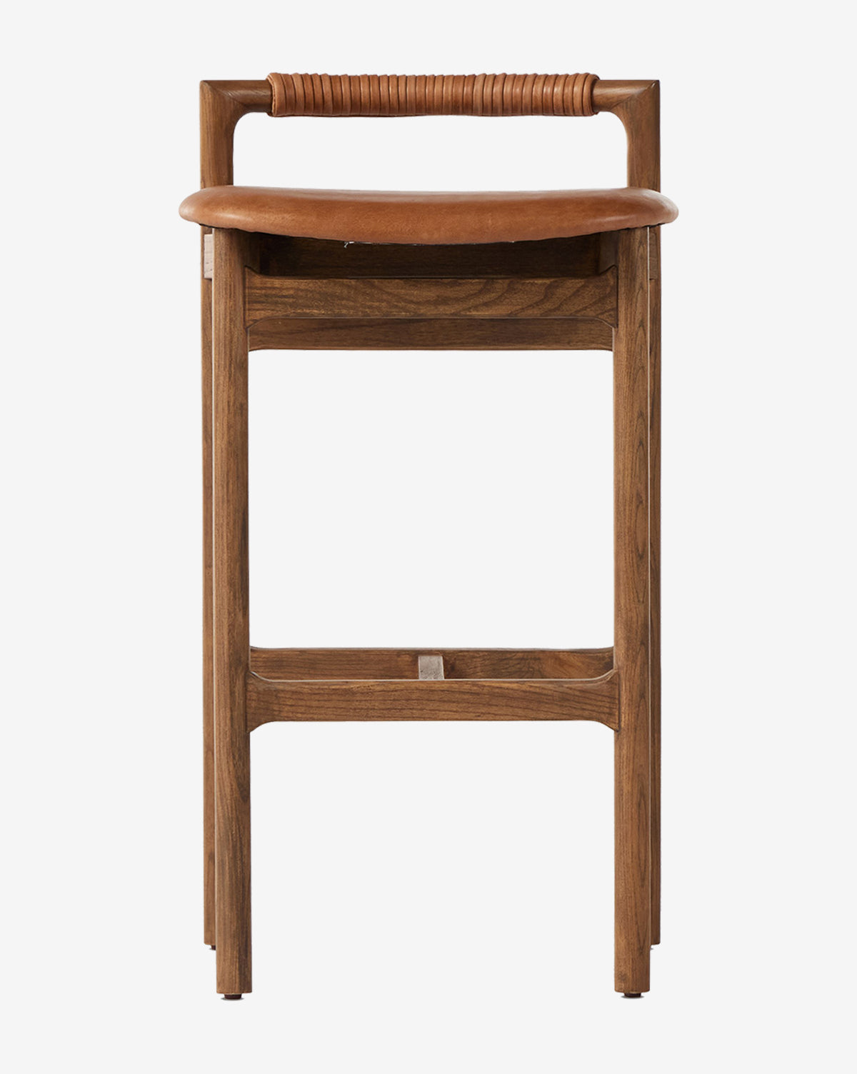 The Four Hands Patrin Stool showcases an ash wood frame and a curved seat, with a horizontal backrest wrapped in leather or wicker, shown front-facing against a white background. McGee & Co.