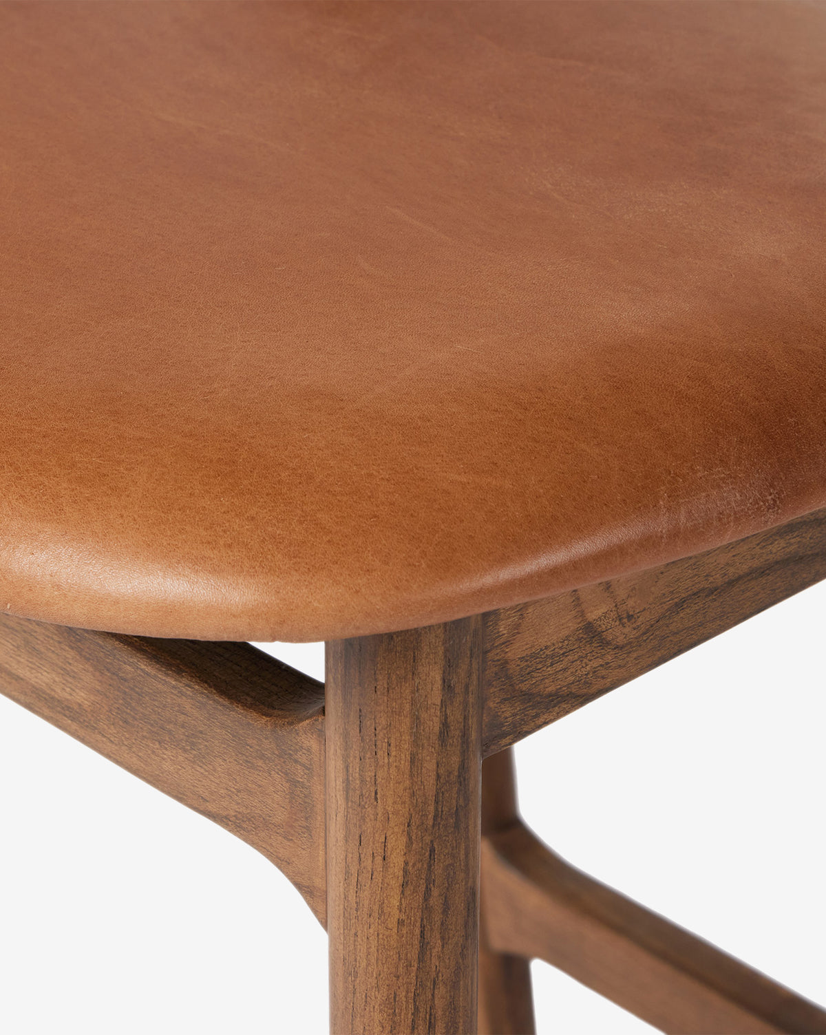 Close-up of the Four Hands Patrin Stool, featuring an ash wood frame and a smooth light brown performance upholstered seat, showcasing quality texture and craftsmanship. McGee & Co.