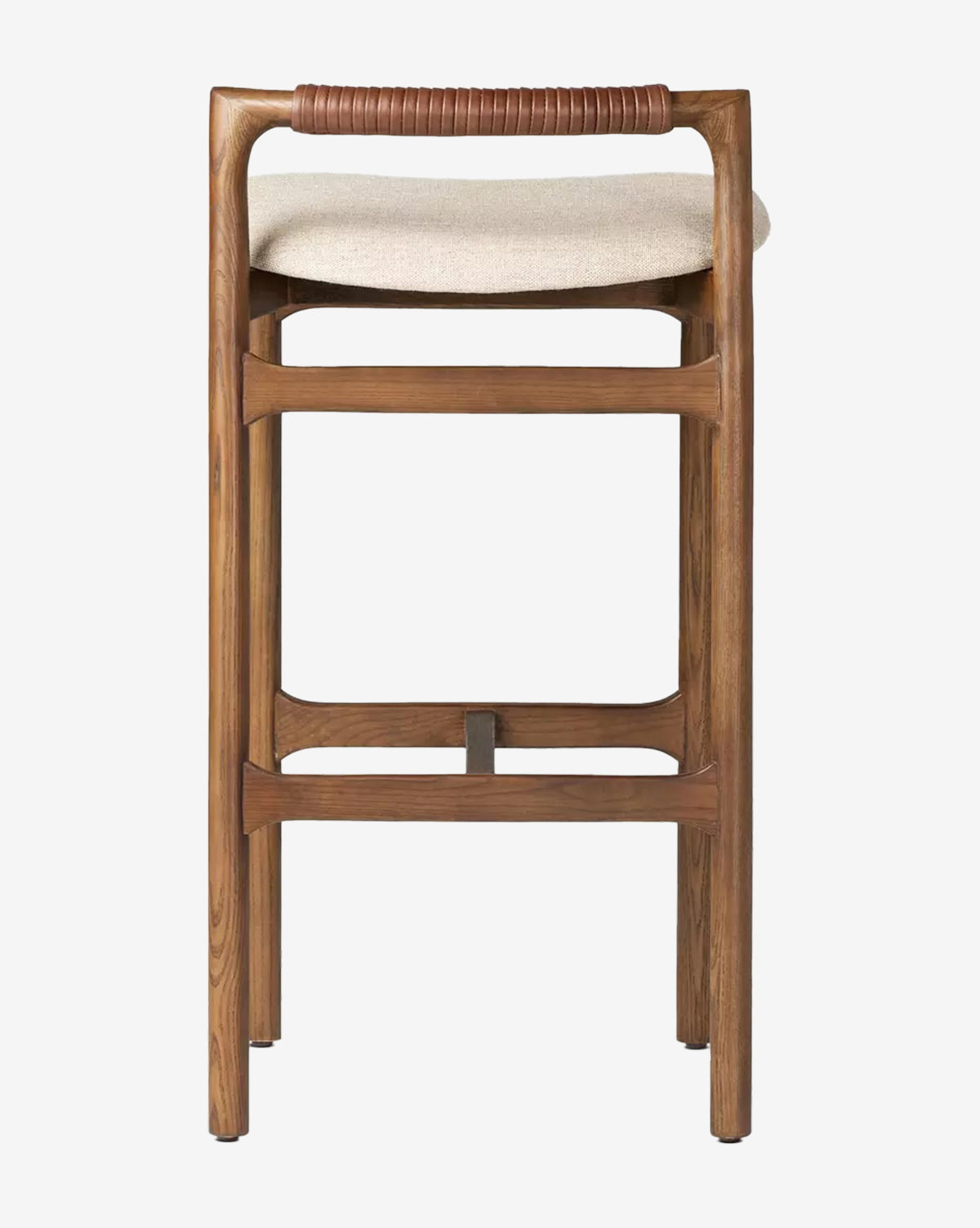 The Four Hands Patrin Stool features an ash wood frame, beige performance upholstery, and a wrapped leather backrest detail for a simple, modern look. McGee & Co.