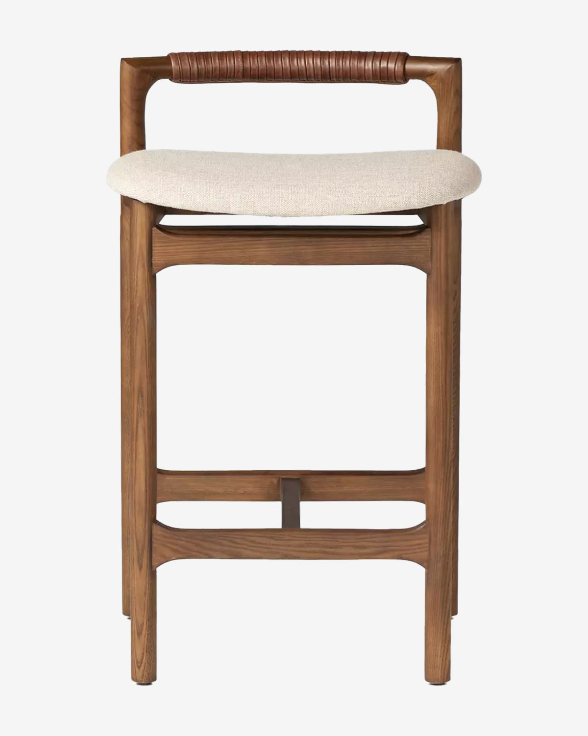 The Four Hands Patrin Stool offers a light beige performance-upholstered seat, a low curved brown leather backrest, and sturdy ash wood legs with horizontal supports, by McGee & Co.
