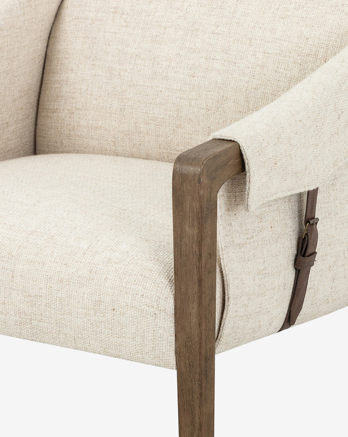 Close-up of the Payson Leather Chair, highlighting its beige performance fabric, wooden armrest, and brown top-grain leather strap accent on the side.