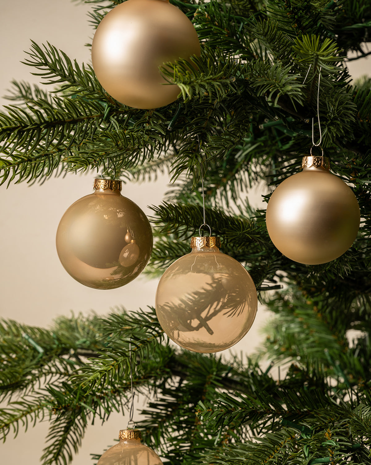 Pearl Glass Baubles (Set of 21 Assorted) adorn the green Christmas tree, adding festive elegance and beautiful neutral tones to your holiday décor, by McGee & Co.