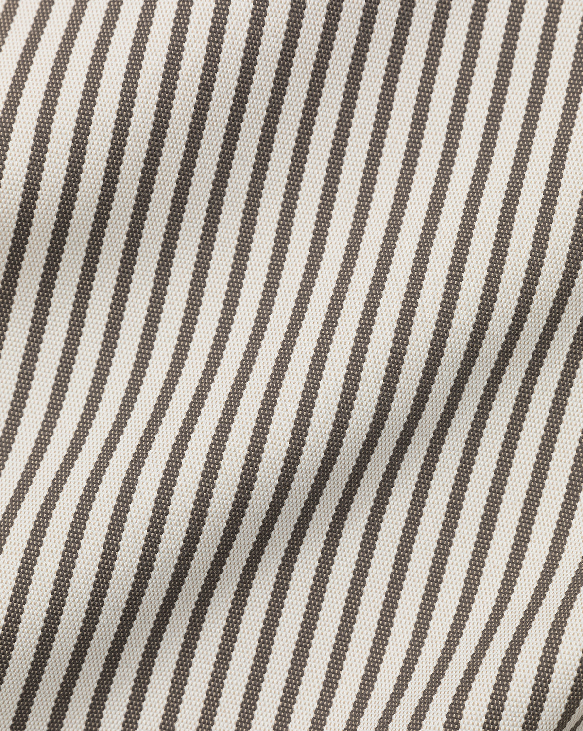 Close-up of the Perennials Upholstery Swatch, featuring black and white vertical pinstripes with a wavy texture and fold shadows. Made from solution-dyed acrylic, it boasts the enduring beauty of high-performance fabrics.