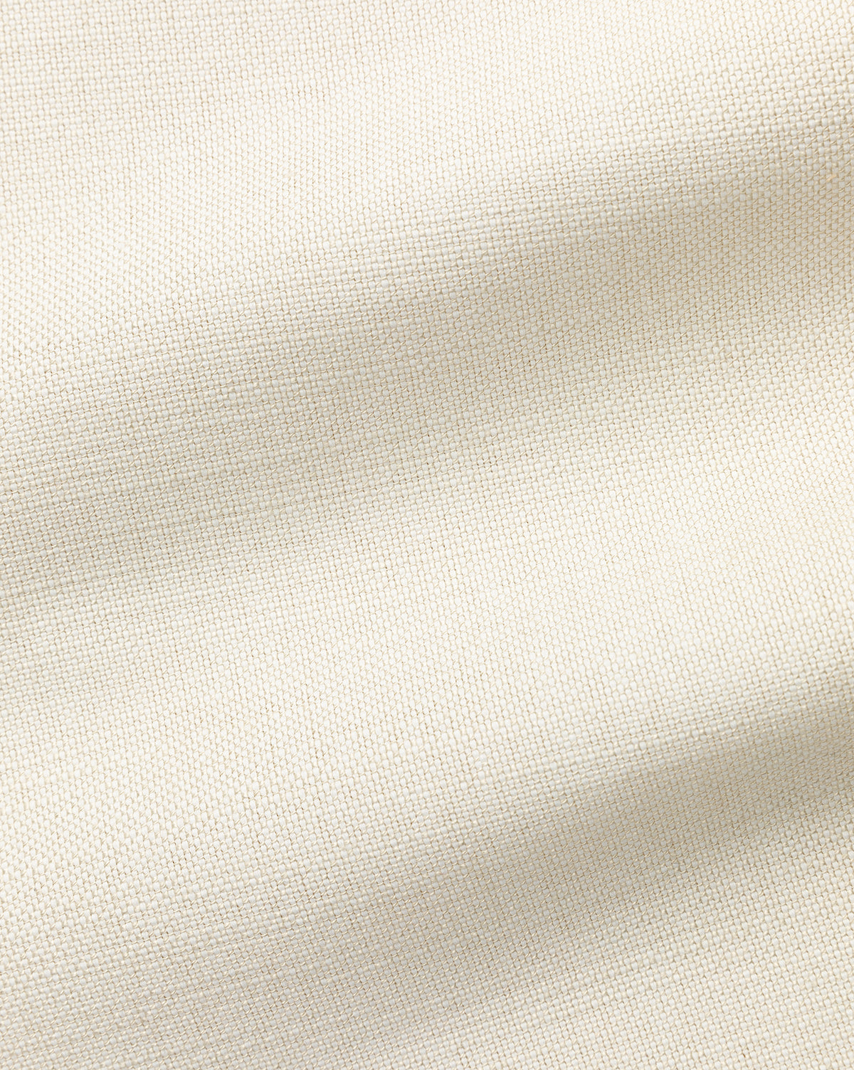 Close-up of a Perennials Upholstery Swatch in light beige, showcasing its textured weave and soft folds. The performance fabric’s smooth, neutral surface creates subtle shadow effects across the material.