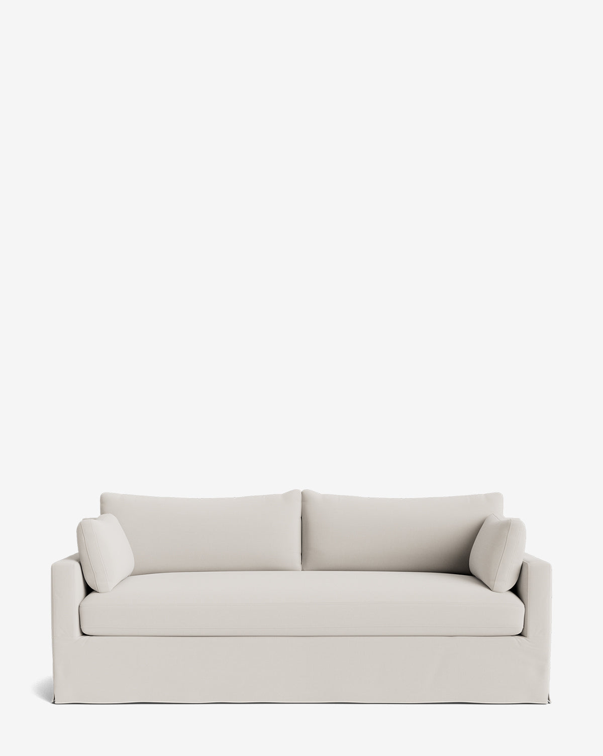 A modern, light beige Peterson Classic Slipcover Sofa (75-100) with feather blend cushions, two seat and back cushions, and two matching cylindrical pillows is set against a plain white background by McGee & Co.