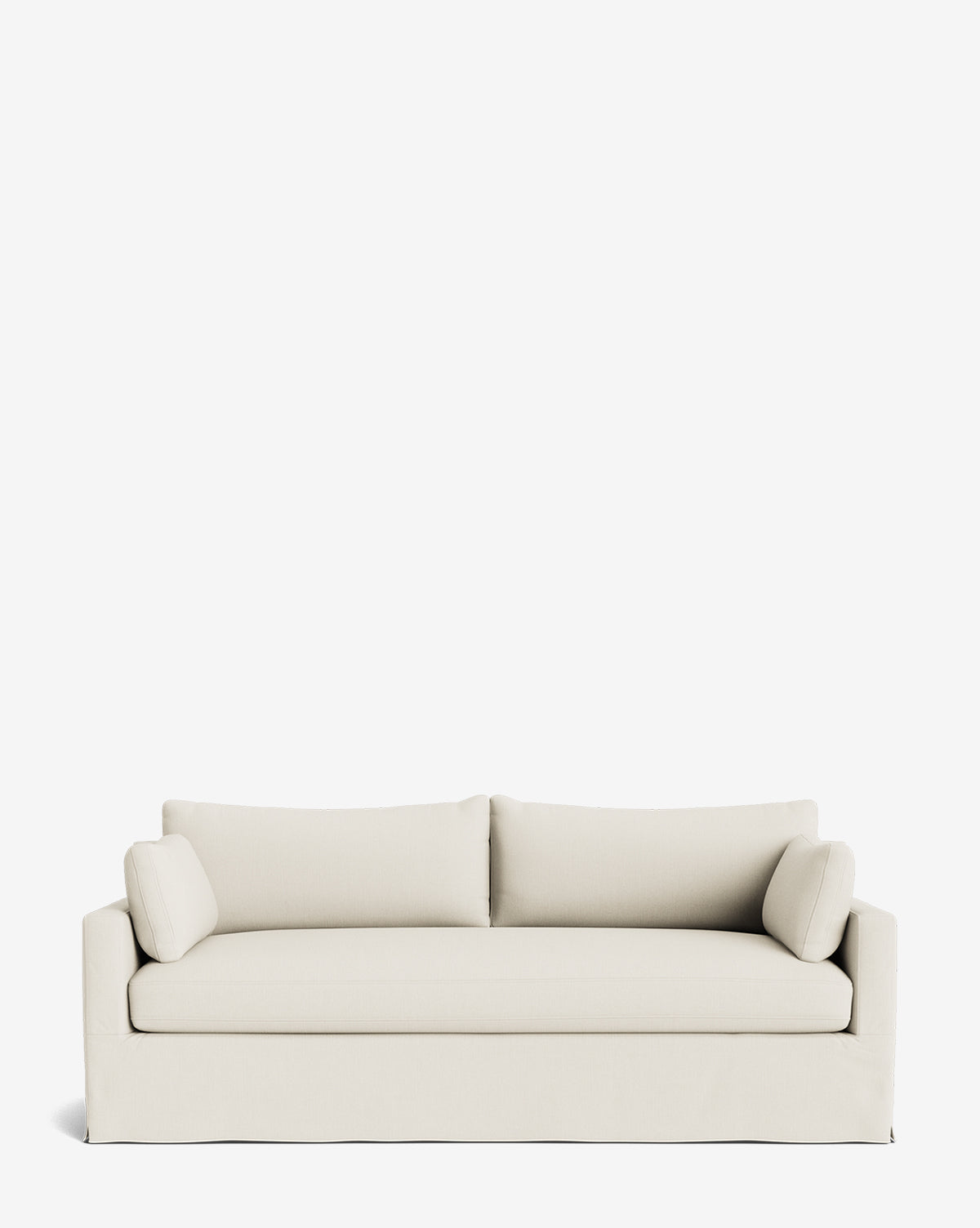A modern Peterson Classic Slipcover Sofa (75-100) in light beige, featuring clean lines, rectangular feather-blend cushions, and two matching bolster pillows, displayed against a plain white background by McGee & Co.