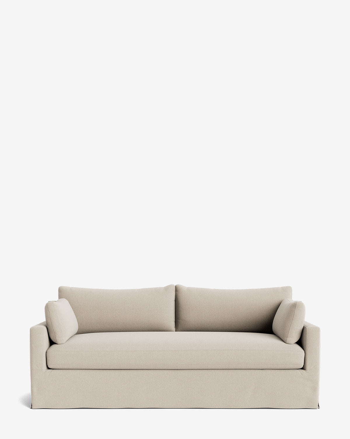 A Peterson Classic Slipcover Sofa (75-100) in light beige with a skirted base, straight arms, feather blend cushions, and two cylindrical side pillows is set against a plain white background by McGee & Co.