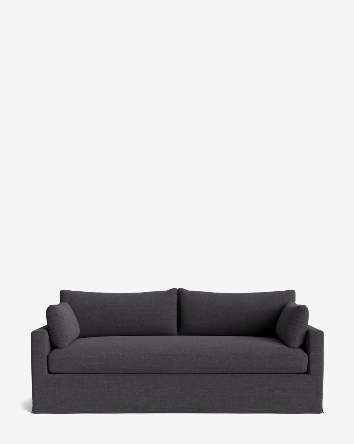 A modern Peterson Classic Slipcover Sofa (75-100) in dark gray with two seat and back cushions, plus two matching cylindrical arm pillows featuring feather blend cushions, shown against a plain white background by McGee & Co.