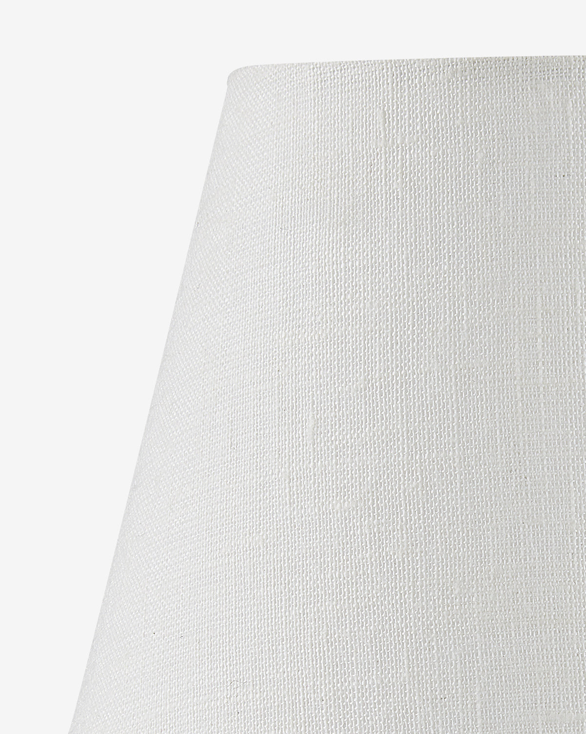 Close-up of the upper part of the Piccolo Table Lamp’s white, textured conical shade, shown against a white background. The elegant lamp features a subtle woven pattern and is complemented by a striking red marble base, by McGee & Co.