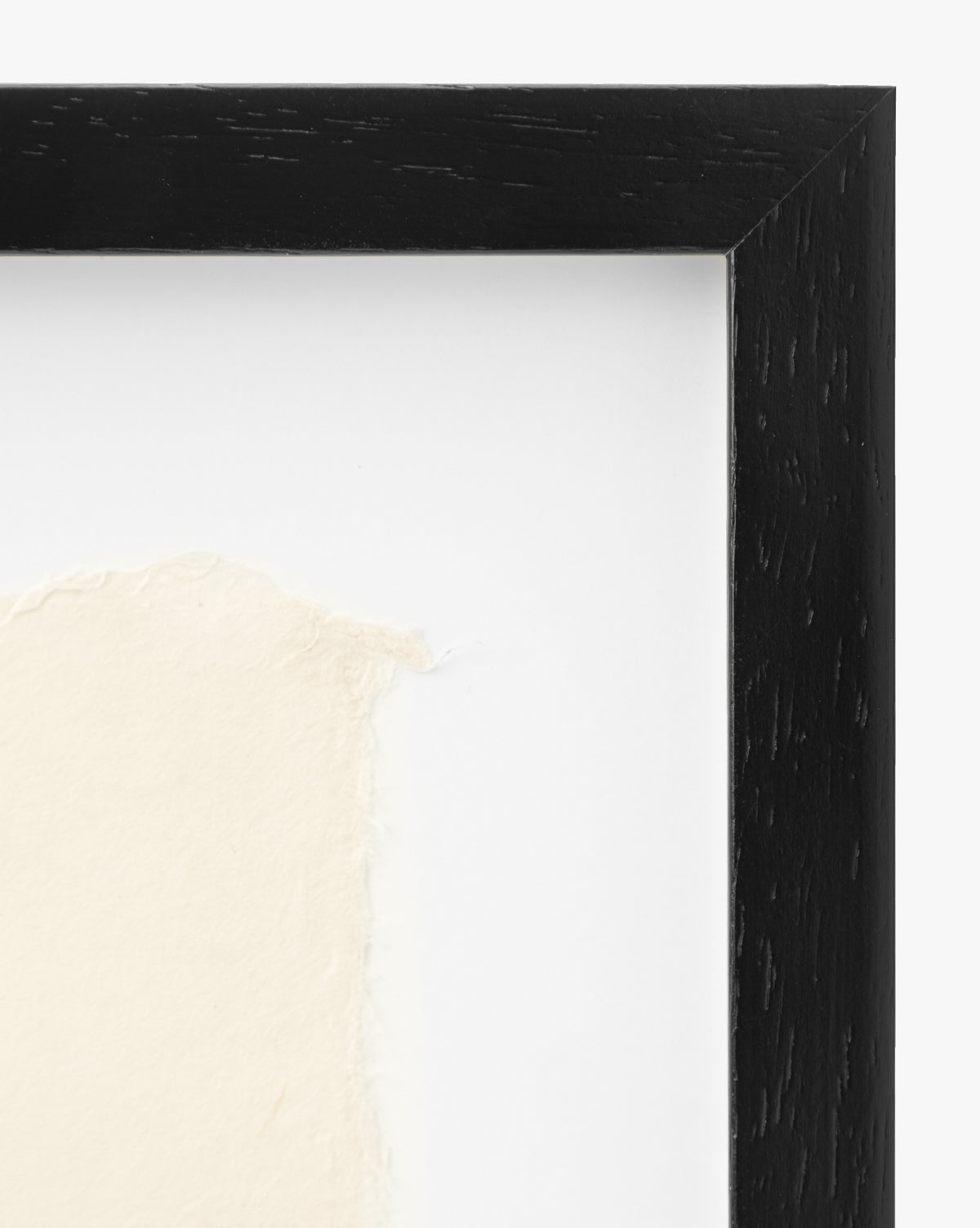 Close-up of the top right corner of the Point Vicente black wooden picture frame with a white mat and textured handmade paper—ideal for displaying vintage wall art.
