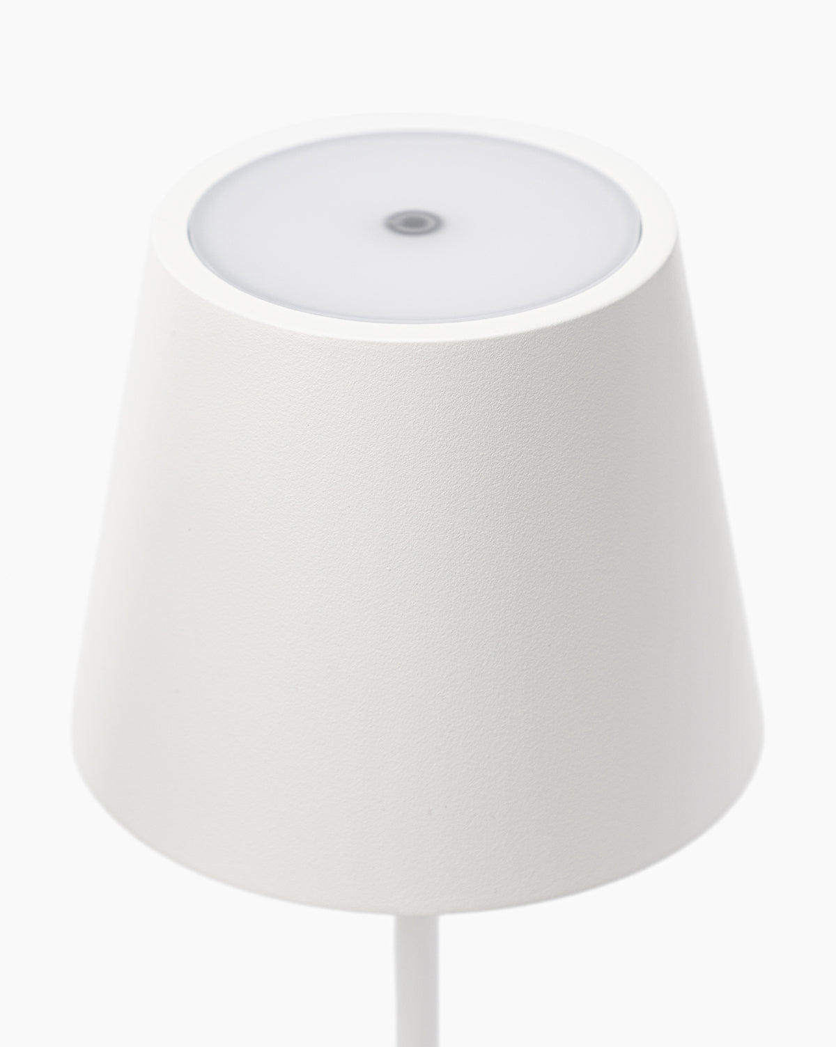 The Poldina Indoor/Outdoor Table Lamp features a minimalistic white conical shade and smooth, circular top, exuding modern elegance. Photographed from above against a plain white background, its sleek design fits any contemporary space by McGee & Co.