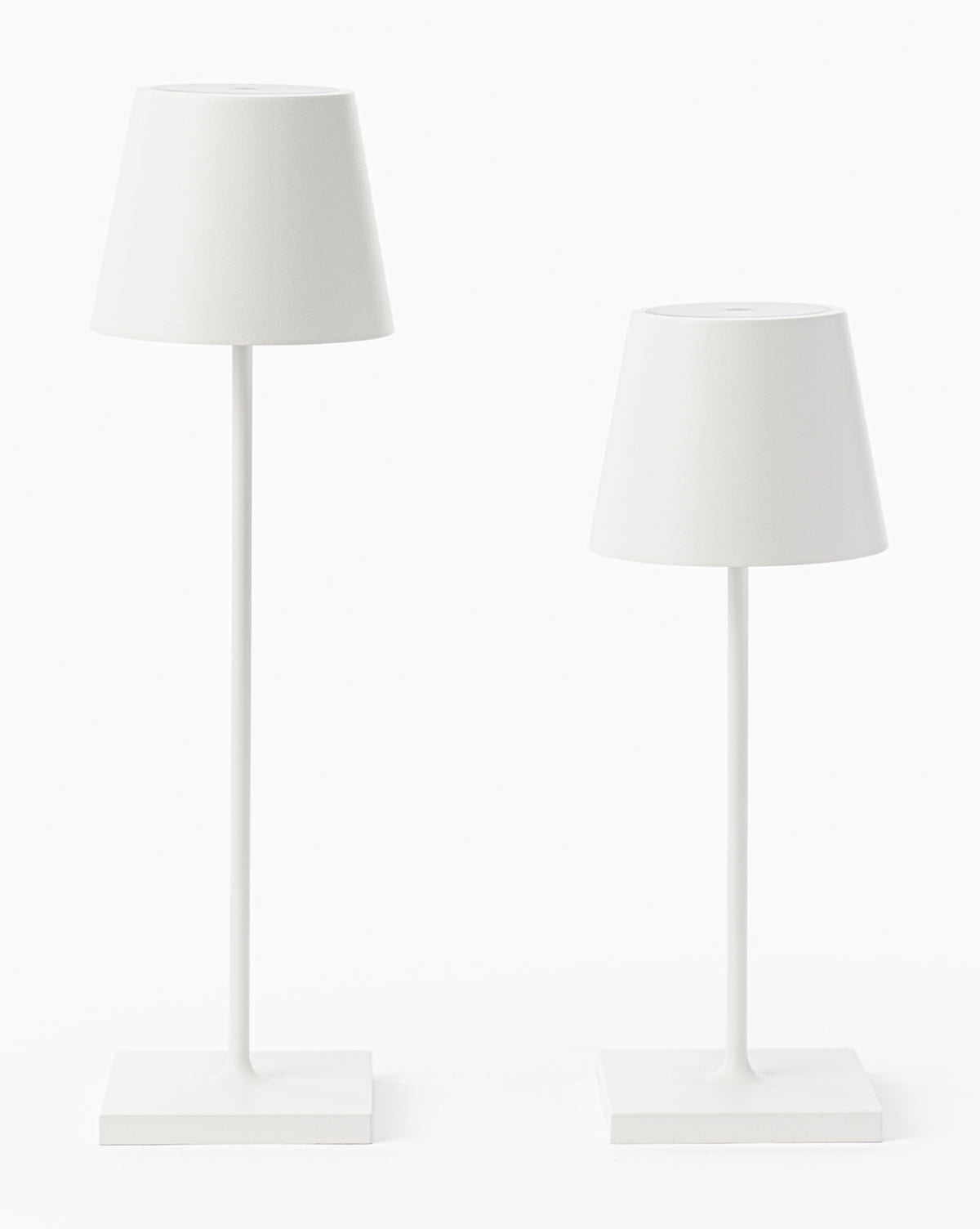 Two minimalist white Poldina Indoor/Outdoor Table Lamps with conical shades and slender stems on square bases showcase modern design. The left lamp is taller, making them perfect for versatile indoor or outdoor use by McGee & Co.