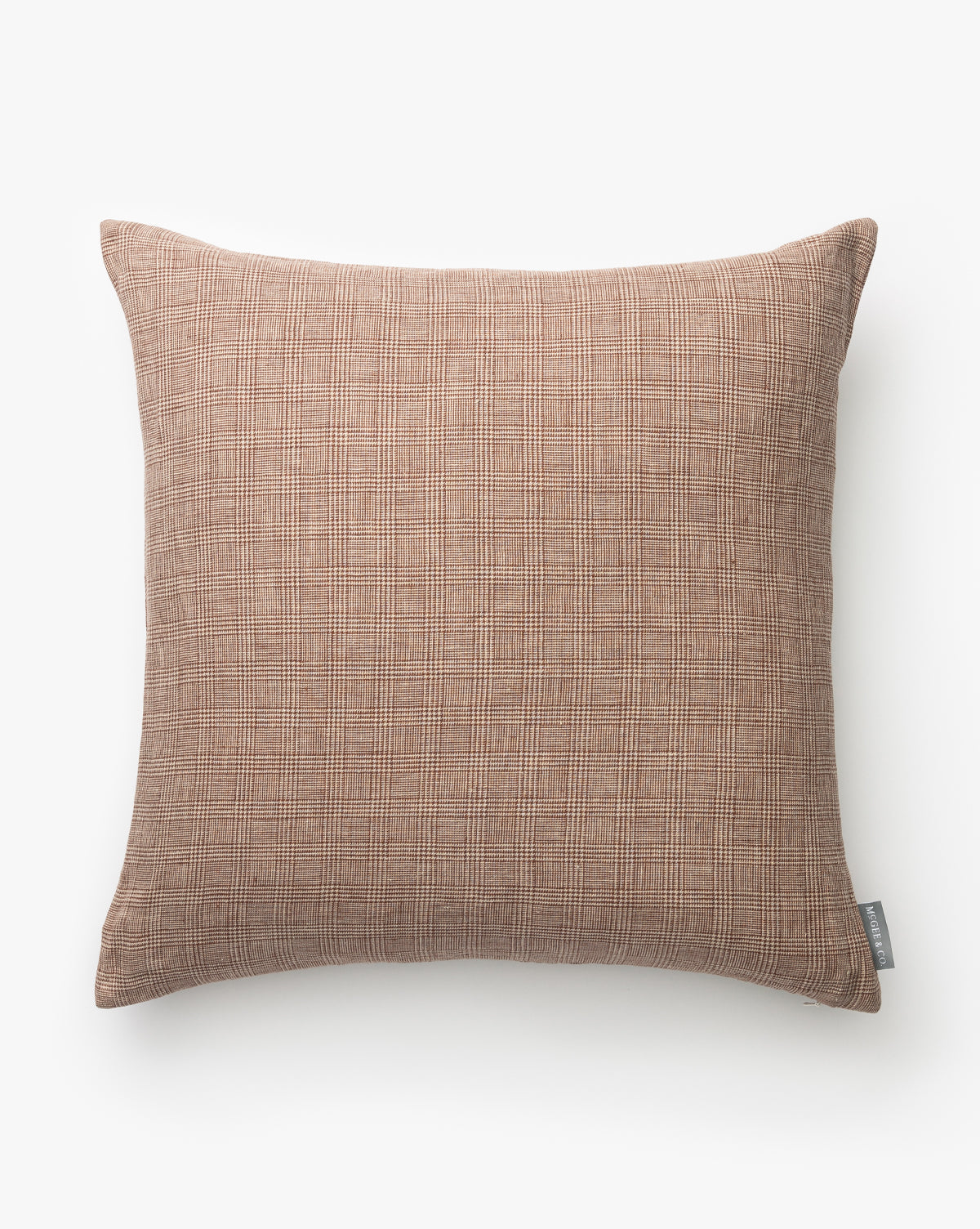 The Polly Pillow Cover is a square, hand-woven linen plaid pillow in light brown with a textured pattern. It features a small gray fabric tag on one side and is displayed against a plain white background by McGee & Co.