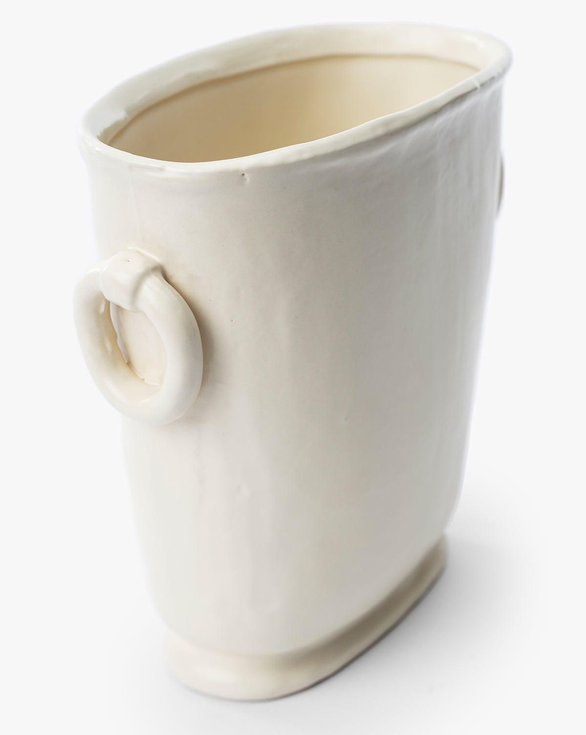 The Powell Ceramic Vase is an off-white, glossy ceramic piece with an irregular oval shape, a slightly uneven rim, and a small circular handle—handcrafted for an organic look thats perfect for unique decorative displays.