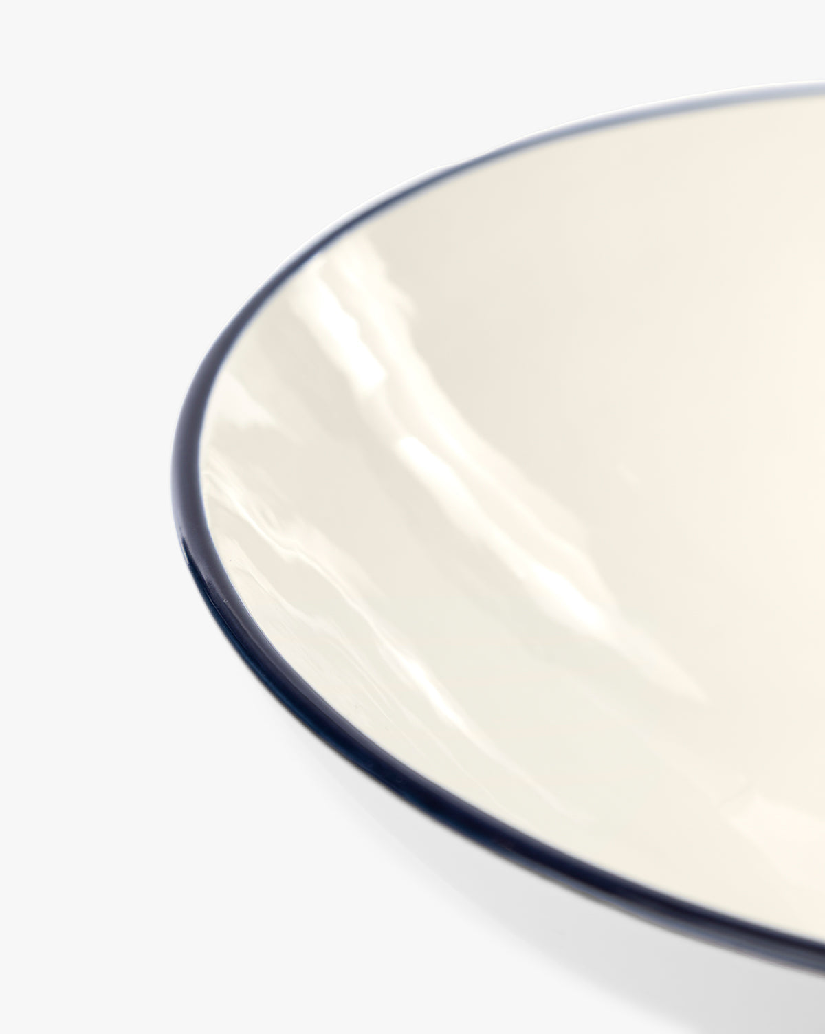 Close-up of the glossy, cream-colored Pritchard Serving Bowl with a dark rim, shown against a white background by McGee & Co.