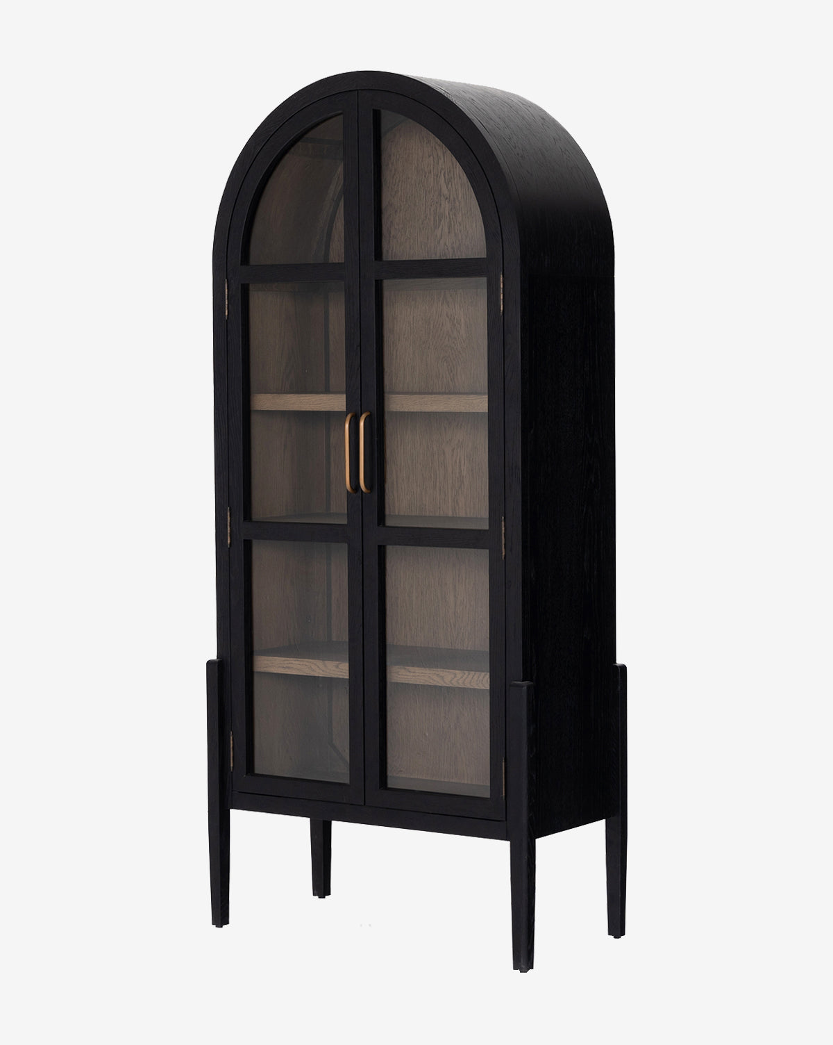 The Providence Cabinet features a black glass front, arched top, gold handles, interior shelving, double doors, and stands on four tall, slender legs by McGee & Co.