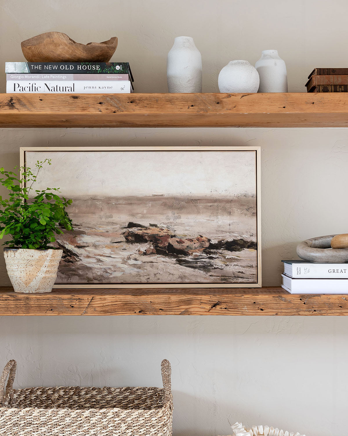 Wooden shelves displaying the Quiet Shore ocean wall art, white vases, stacked books, a potted plant, and a decorative bowl create a cozy, minimalist look—ideal for gallery wall decor enthusiasts seeking natural style.