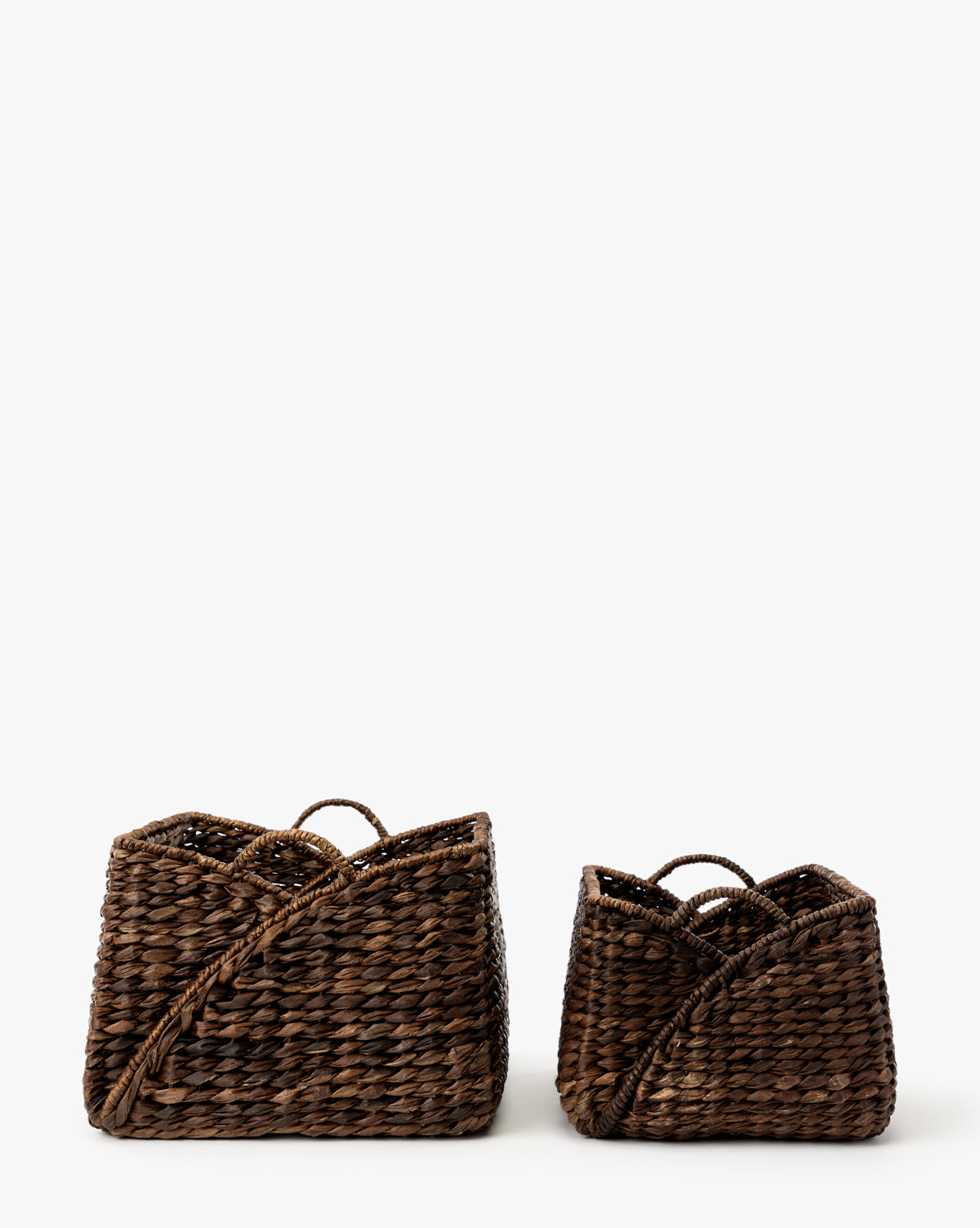 The Quimby Baskets (Set of 2) are rectangular, dark brown handwoven baskets with curved edges and handles, shown side by side against a white background, with the left basket larger than the right, by McGee & Co.