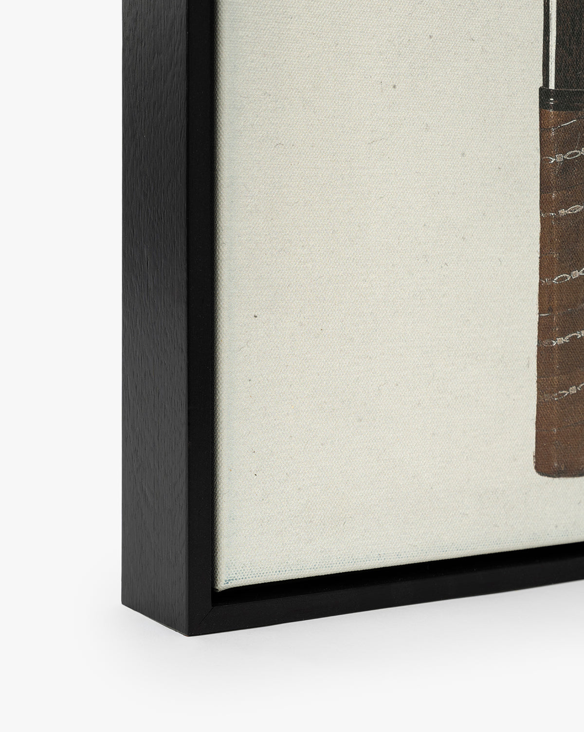 Close-up of the Rackets 1 framed canvas artwork, featuring a black woodgrain frame, by McGee & Co. The mostly off-white canvas showcases part of a brown, textured shape for vintage wall art appeal.