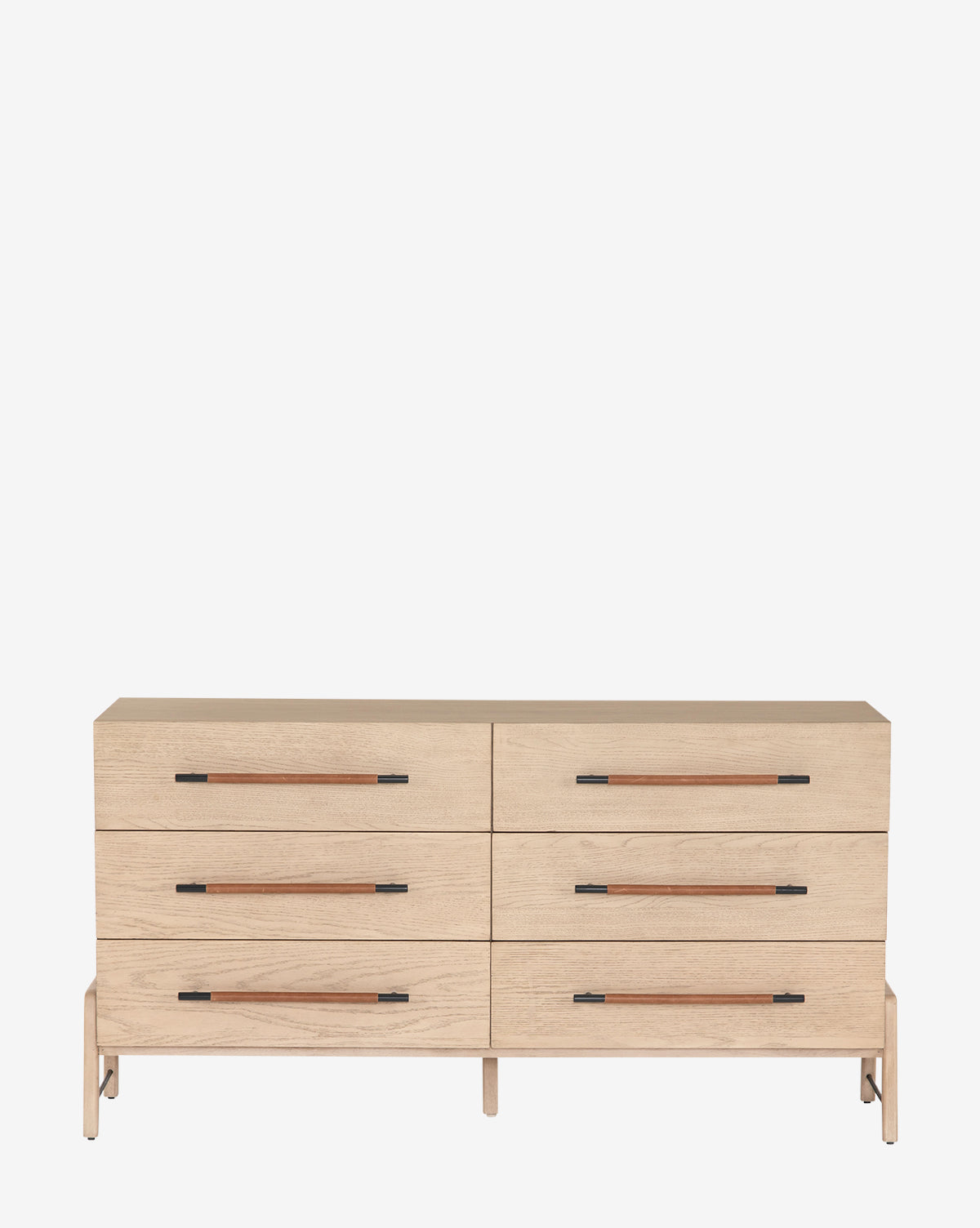 The Ralston 6-Drawer Dresser features six horizontal drawers, slim black handles, a light oak finish, and short legs, offering a minimalist design perfect for modern spaces.