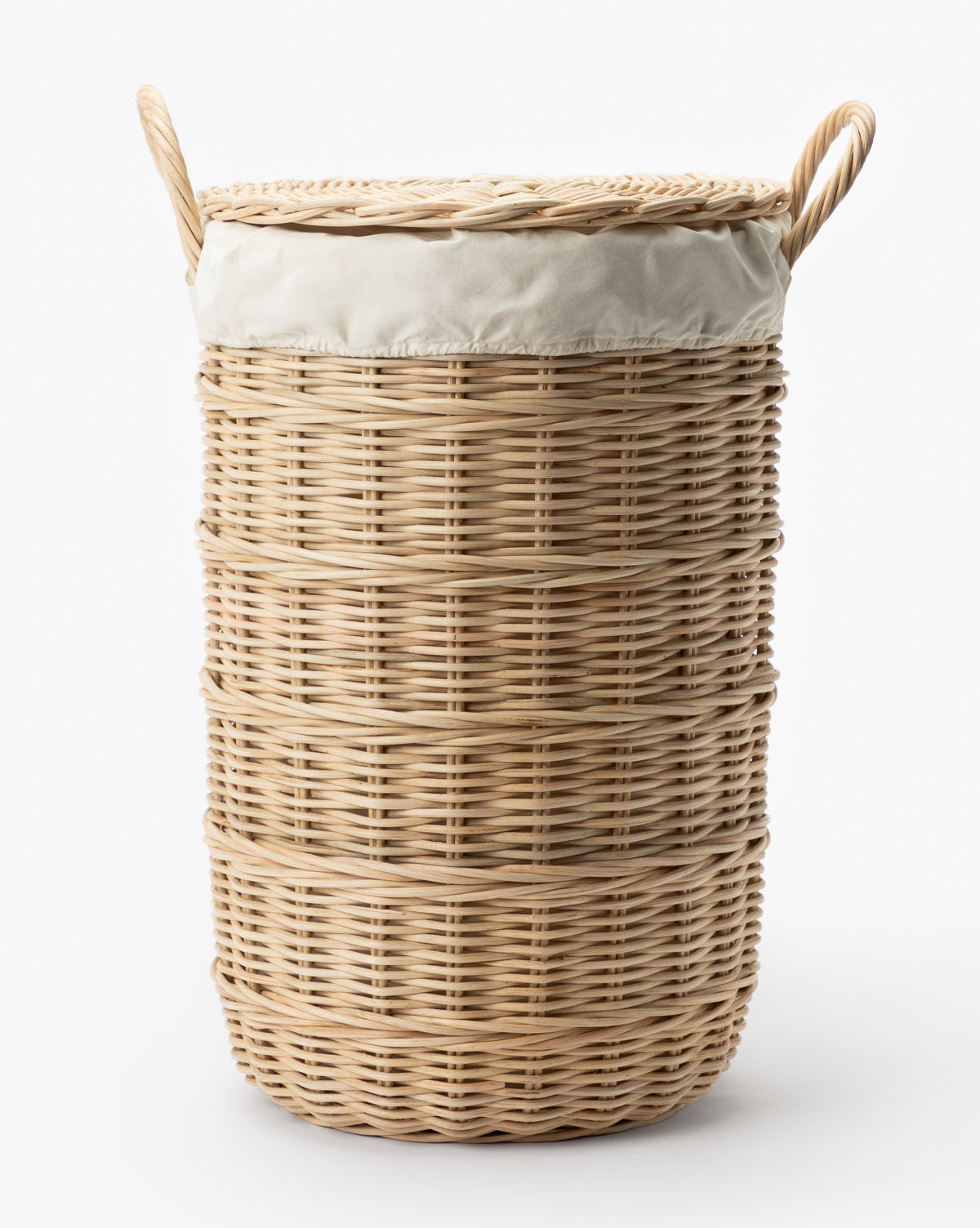 The Rattan Lidded Laundry Bin features a tall cylindrical design, two handles, a matching lid, and a fitted cream fabric liner—ideal for stylish organization in your laundry room. Shown against a white background.