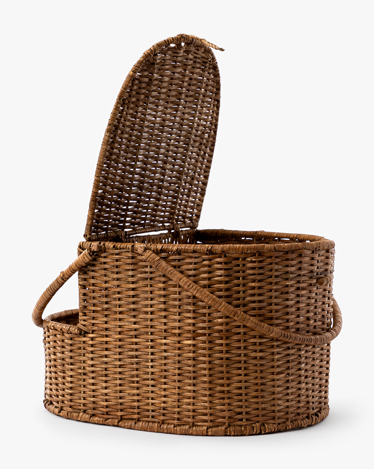 The Rattan Wicker Picnic Basket features an oval shape, hinged lid partially open, and two side handles—ideal for picnics or home organization, by McGee & Co. Displayed on a plain white background.