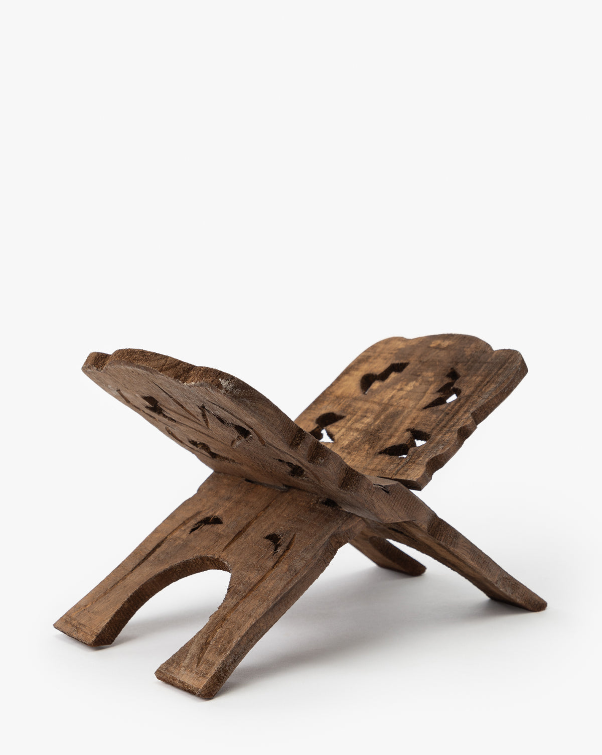 The Reclaimed Wood Book Stand features an X-shaped design with intricate carvings, displayed open on a white background and ready to hold a book by McGee & Co.