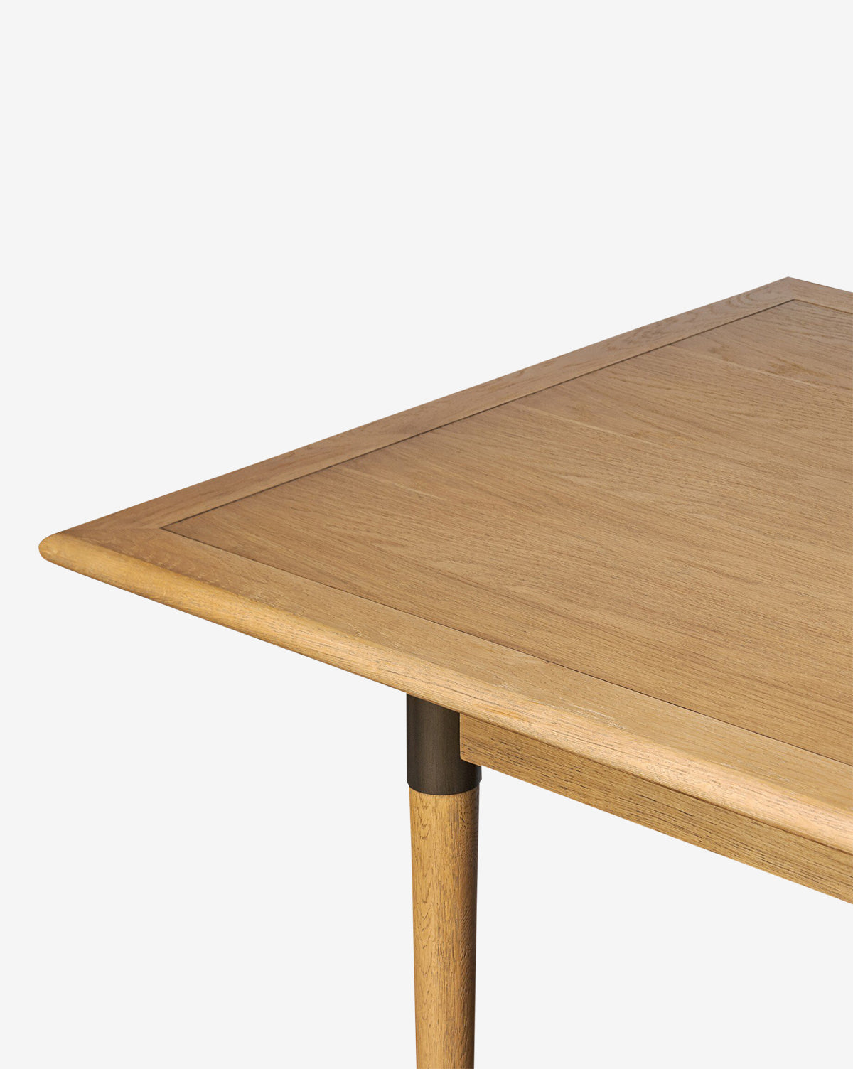 A close-up spotlights the Redmond Extension Dining Table’s light brown wood grain, rounded edges, and sturdy leg against a plain white background—exemplifying its Scandinavian-inspired design for modern dining spaces, by McGee & Co.