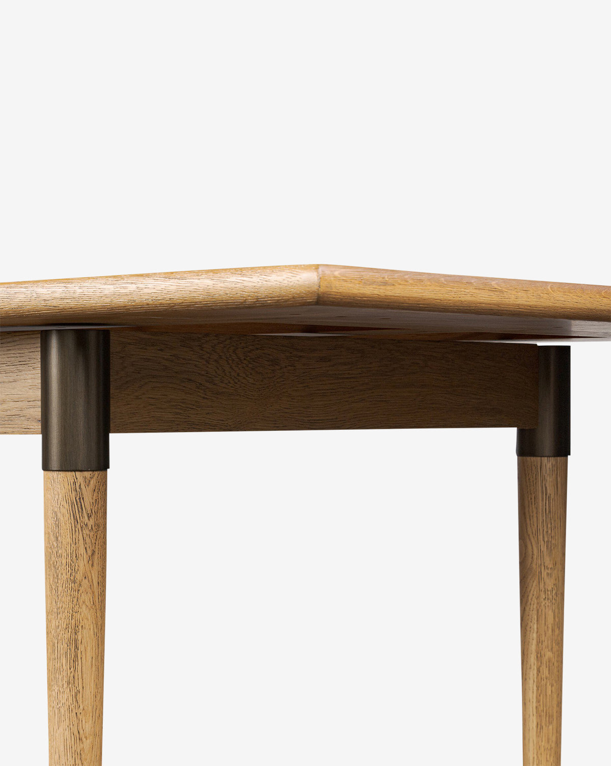 Close-up of the Redmond Extension Dining Tables corner, showcasing its Scandinavian style, rounded edges, and four cylindrical legs against a plain white background by McGee & Co.