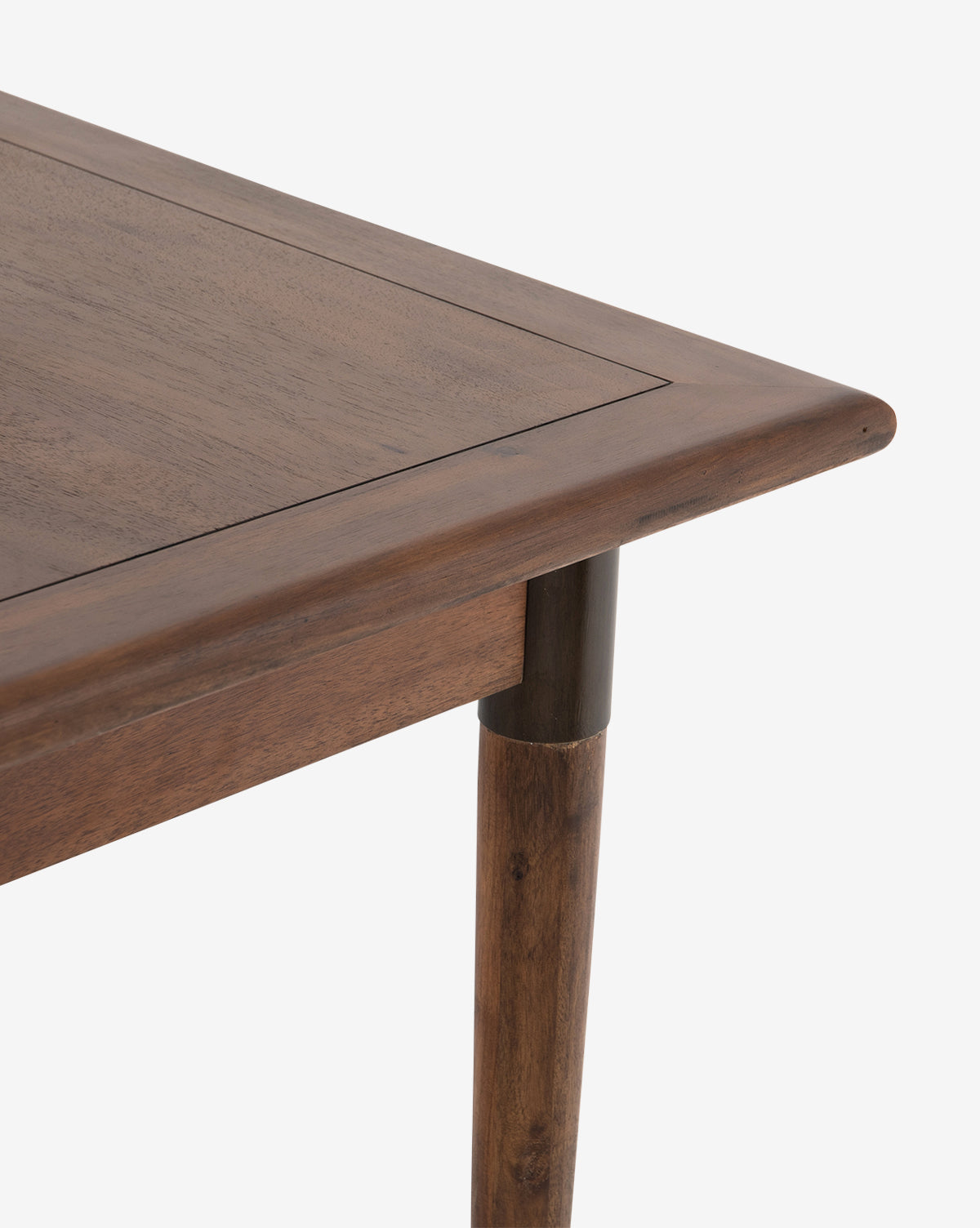 A close-up of the Redmond Extension Dining Table’s corner shows its tapered legs, smooth finish, and natural wood grain—an elegant nod to Scandinavian design—set against a plain white background by McGee & Co.