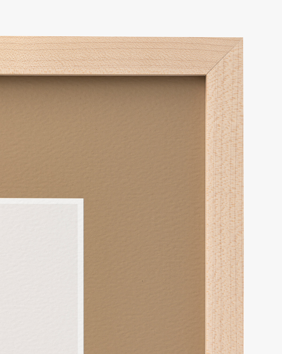 A close-up of the top right corner of a Rex maple frame, featuring part of a matted image with a brown background and white border—ideal for displaying nursery wall art, by McGee & Co.