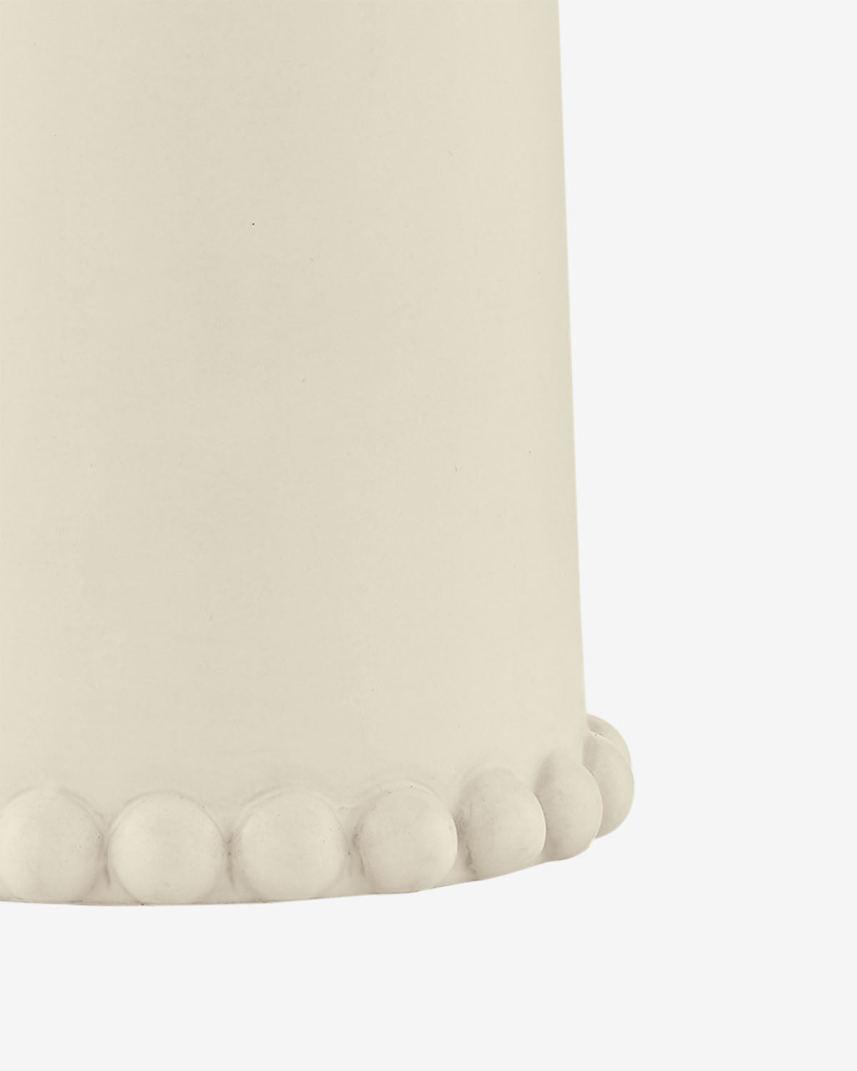 Close-up of the lower part of the Rhea Table Lamp in a neutral tone, featuring a row of round, raised bumps along the bottom edge against a white background, by McGee & Co.