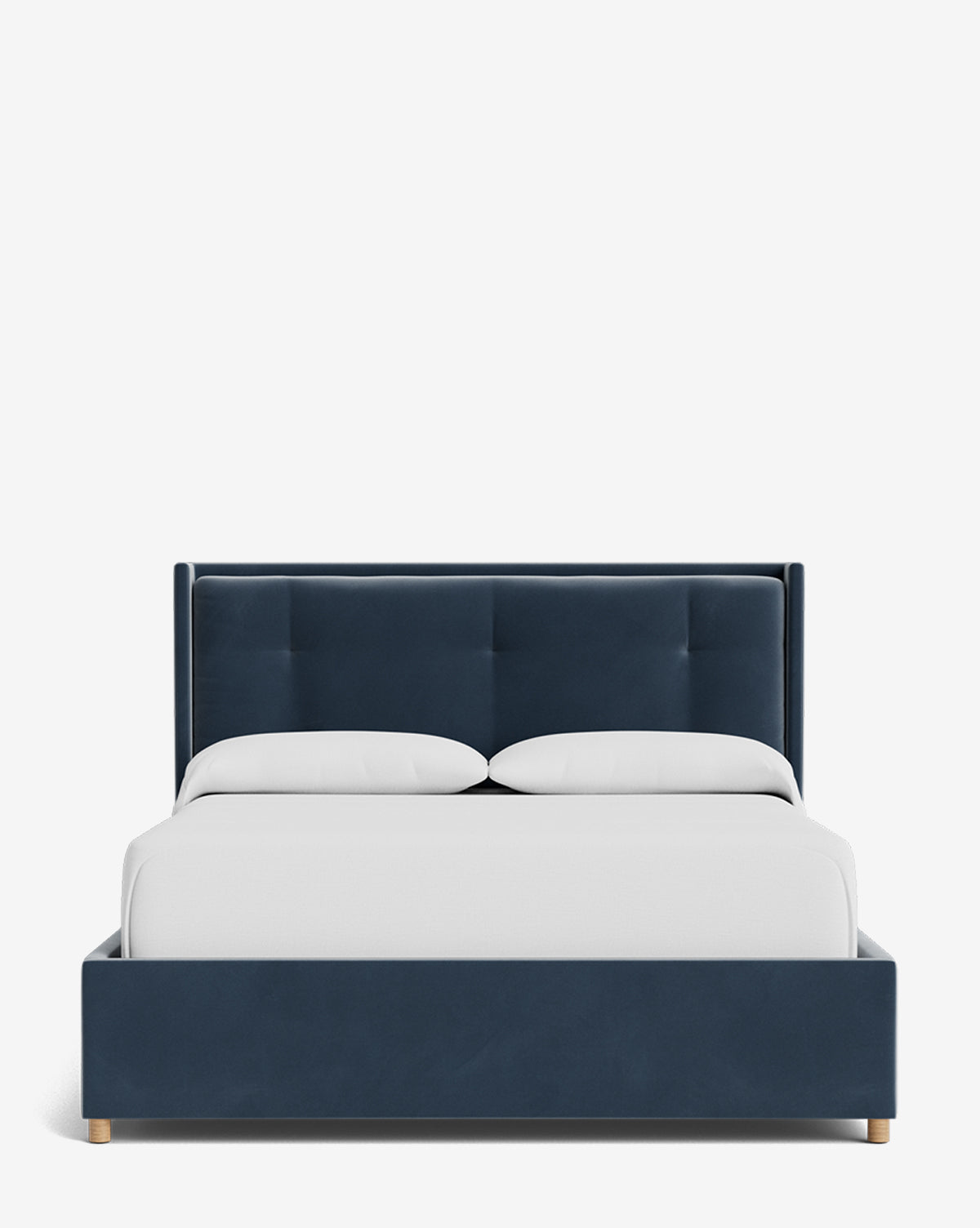 The Ria Bed Low Headboard features a navy blue upholstered frame, a tufted headboard, two white pillows, and a white blanket, all set against a plain white background by McGee & Co.
