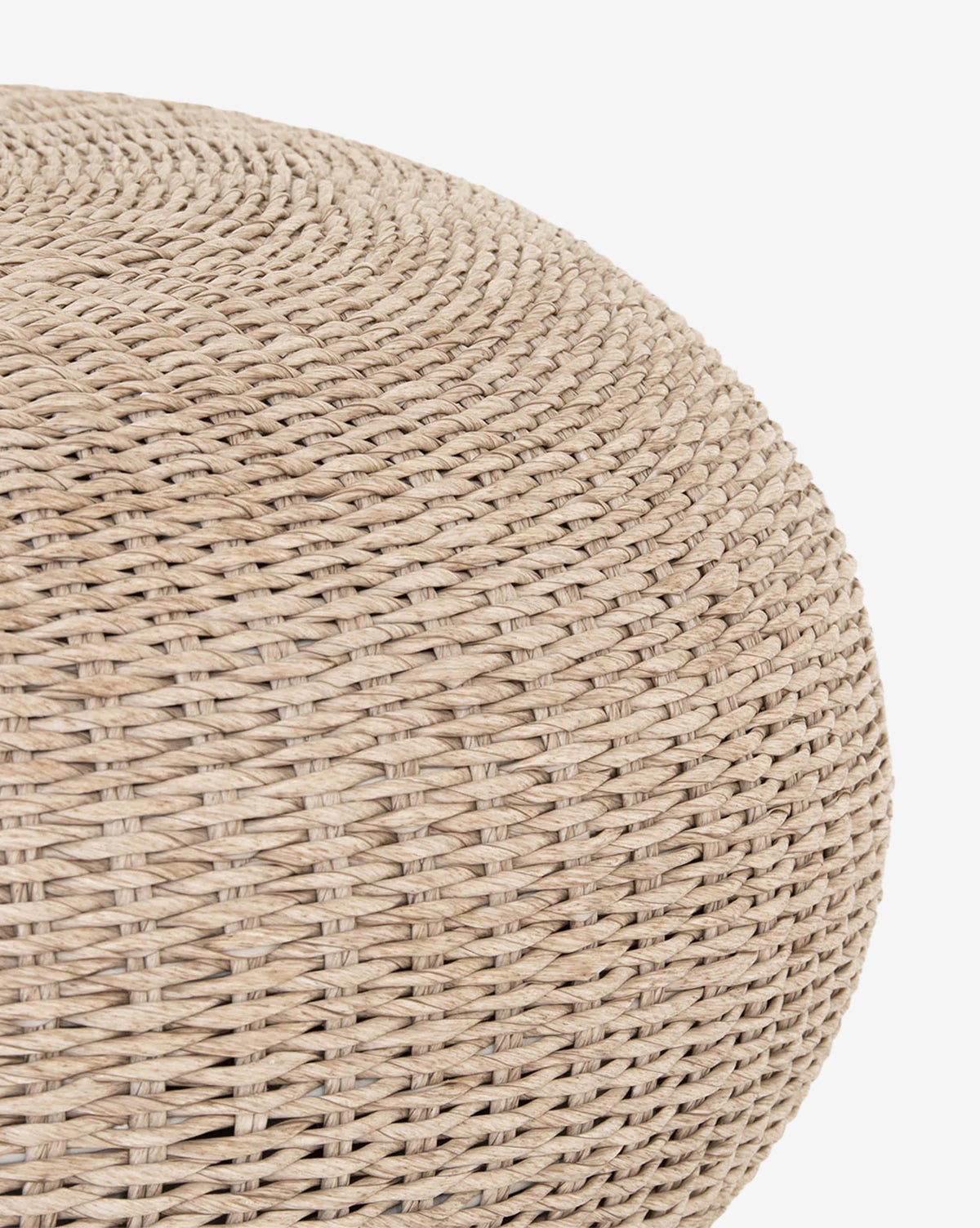 Close-up of the Rimma Outdoor Coffee Table, a round beige all-weather wicker piece with a smooth, curved surface and tightly braided texture, shown on a white background, by McGee & Co.
