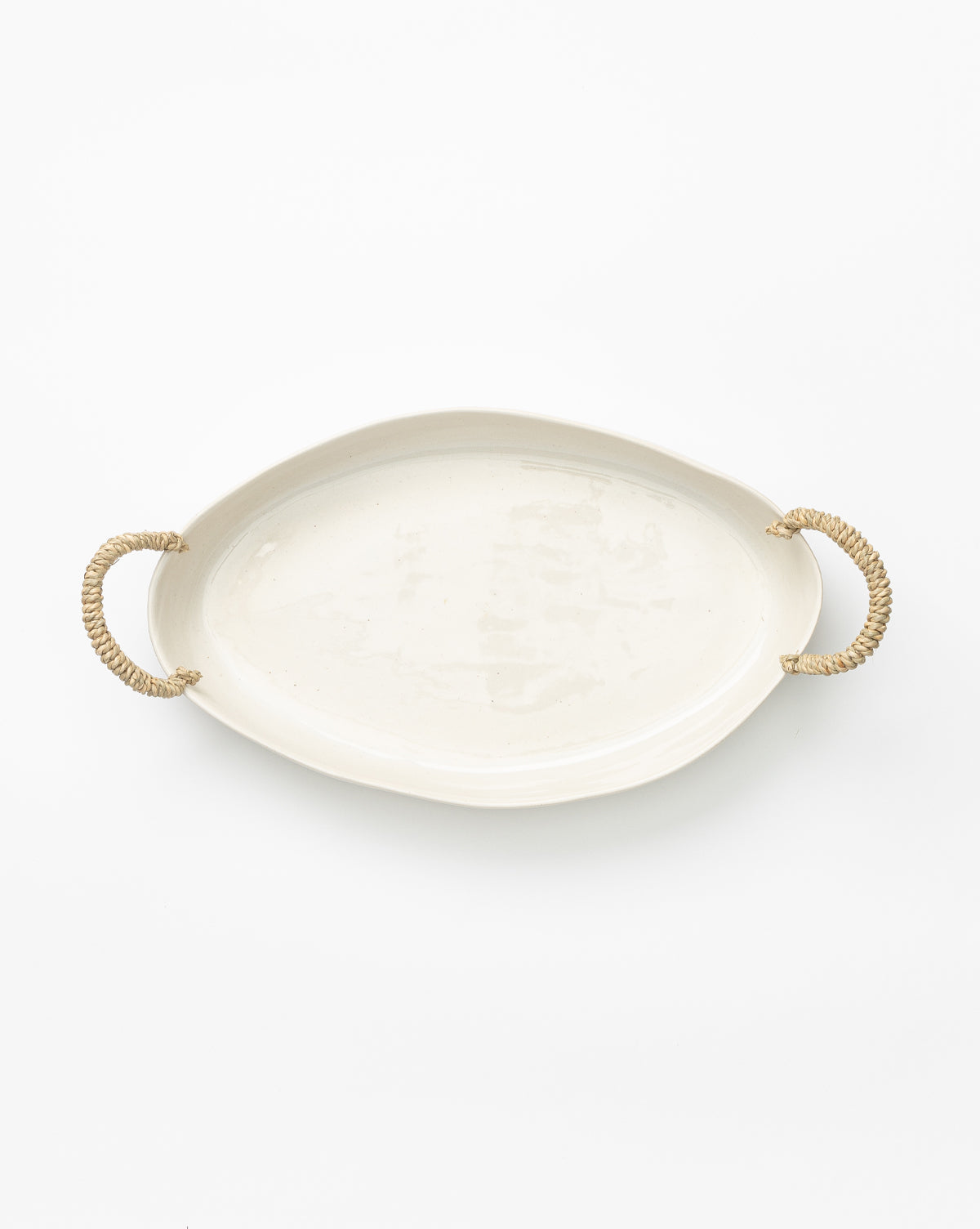 The Rio Oval Tray is a white ceramic kitchen tray with two woven rope handles on each side, shown against a plain white background by McGee & Co.