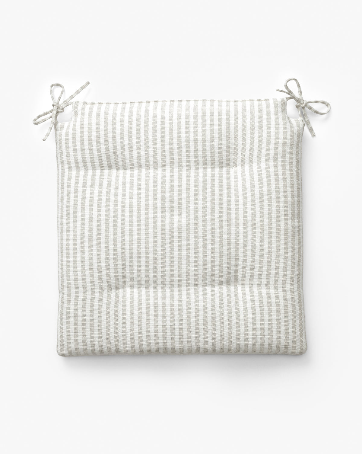 The Credence Romany Dining Chair Cushion is a square, padded linen cushion with light gray and white stripes and two pairs of top-corner ties, ideal for adding comfort and style to your chair. Shown on a white background. McGee & Co.