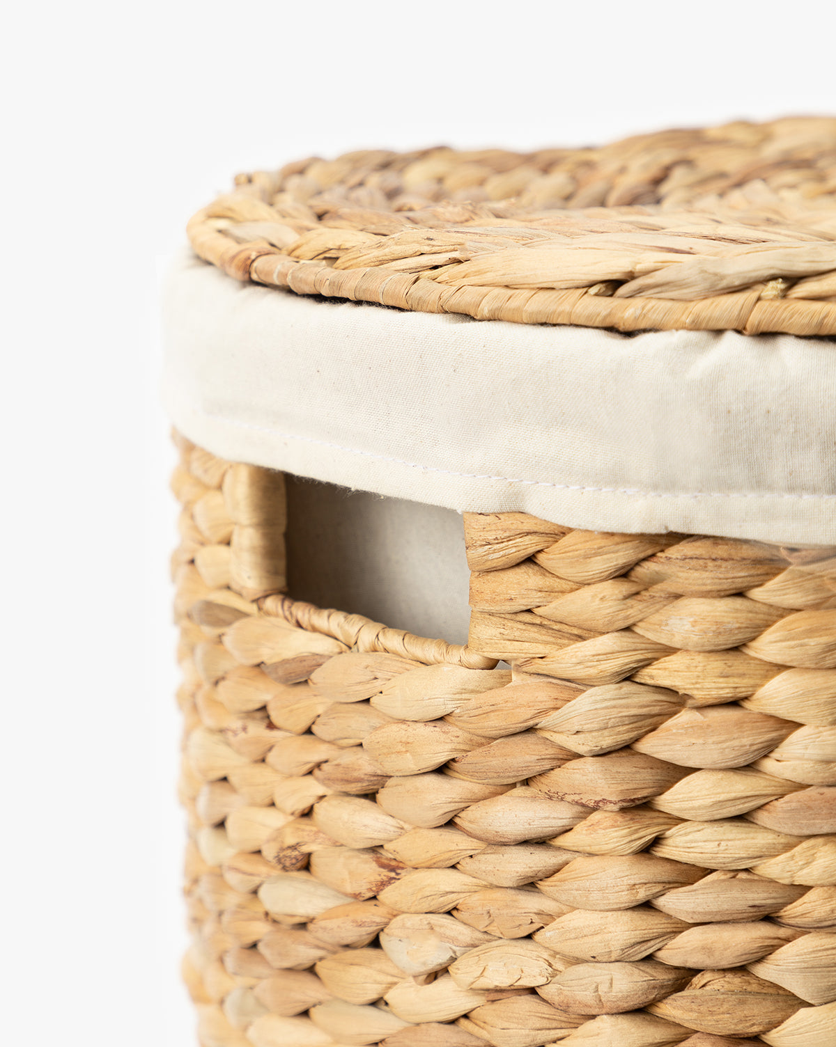 Close-up of the Round Water Hyacinth Basket, featuring natural woven material, a light fabric lining with matching lid, and a small rectangular side handle opening.