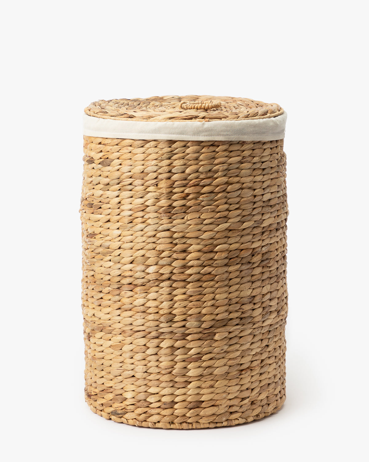The Round Water Hyacinth Basket features a woven design with a fitted lid and light fabric trim near the top, crafted from natural materials and shown against a plain white background.